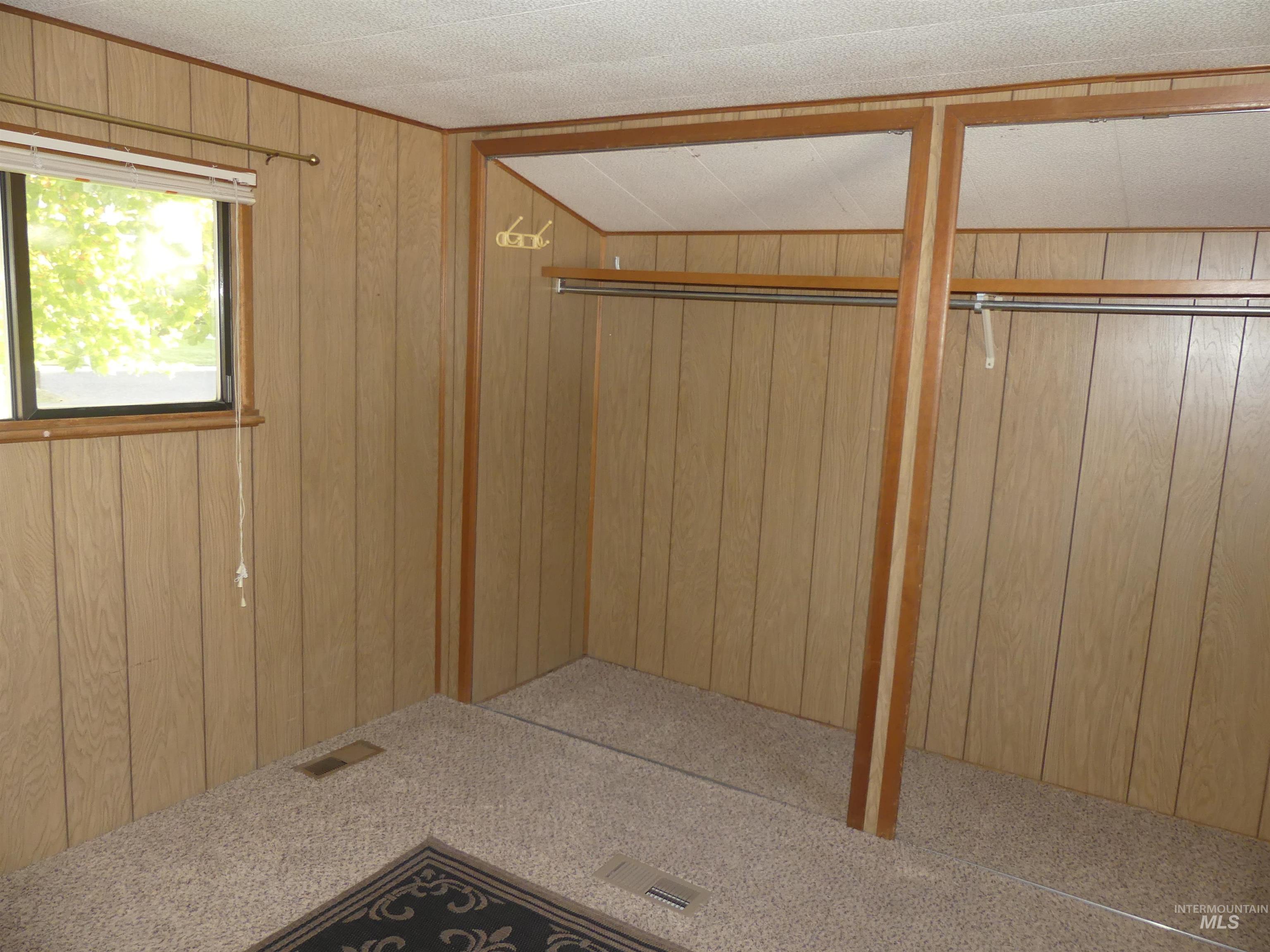 Mudroom with wooden walls and carpet