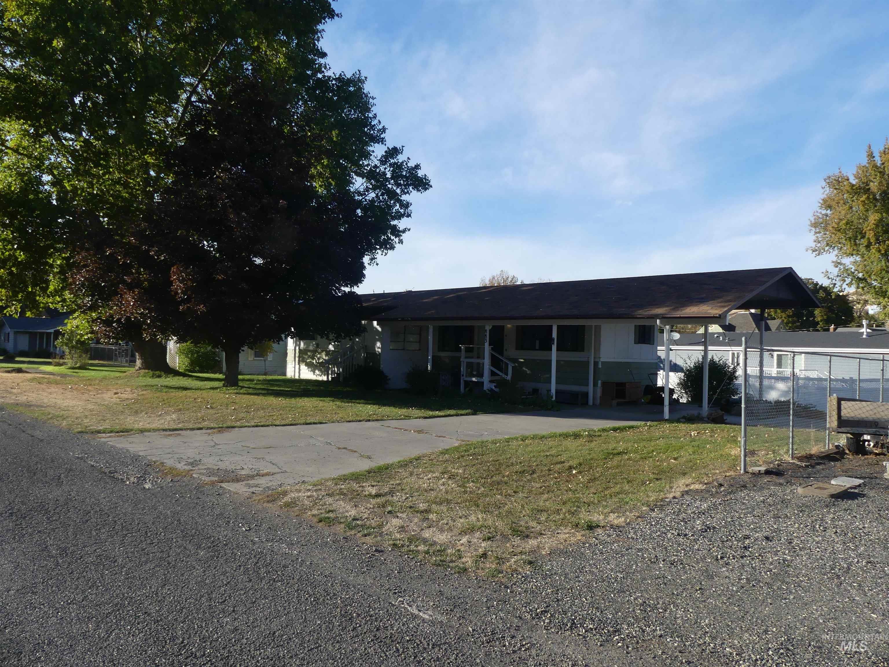 Ranch-style house featuring an attached carport and driveway