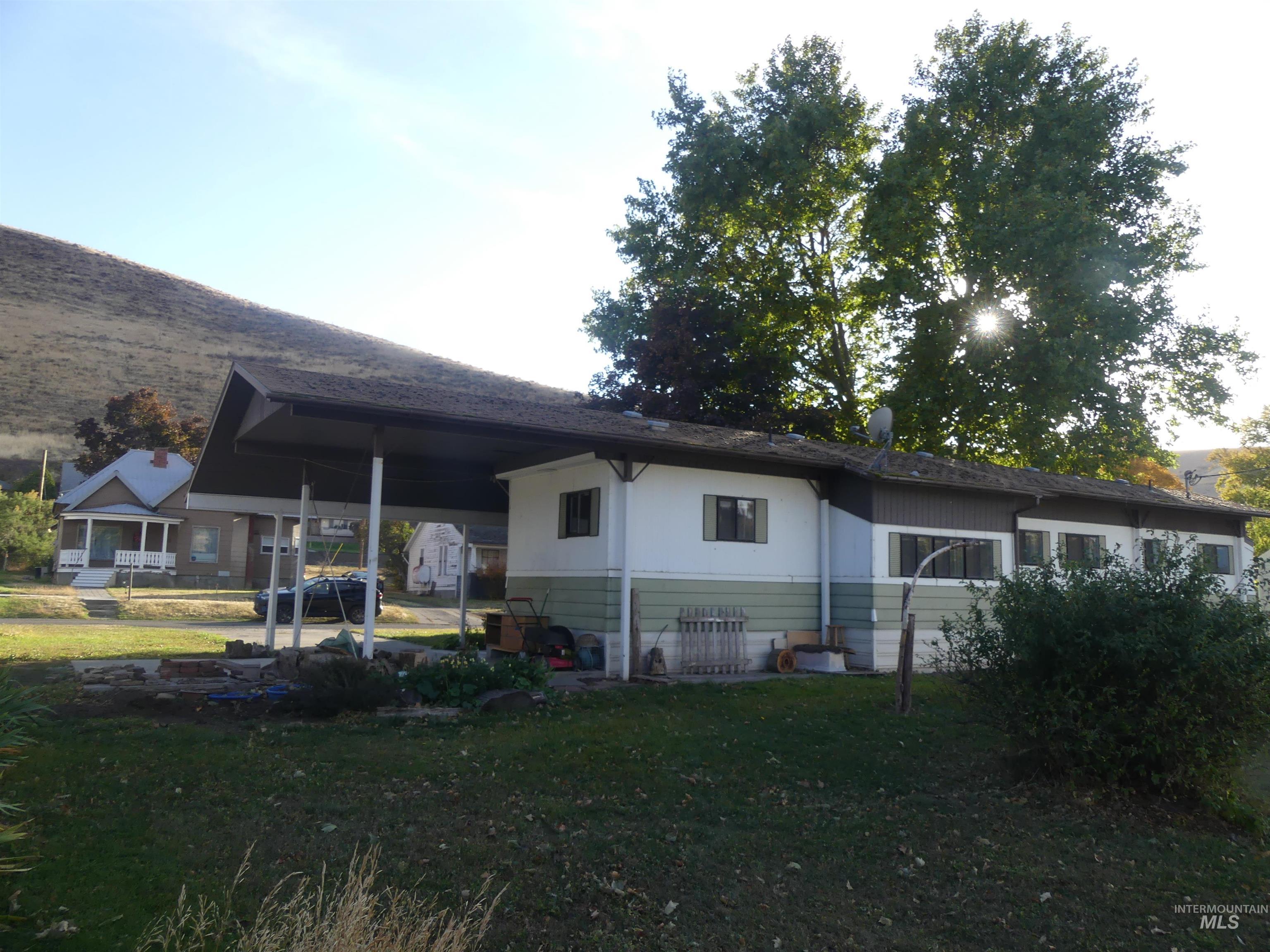 Back of house featuring a yard and a carport