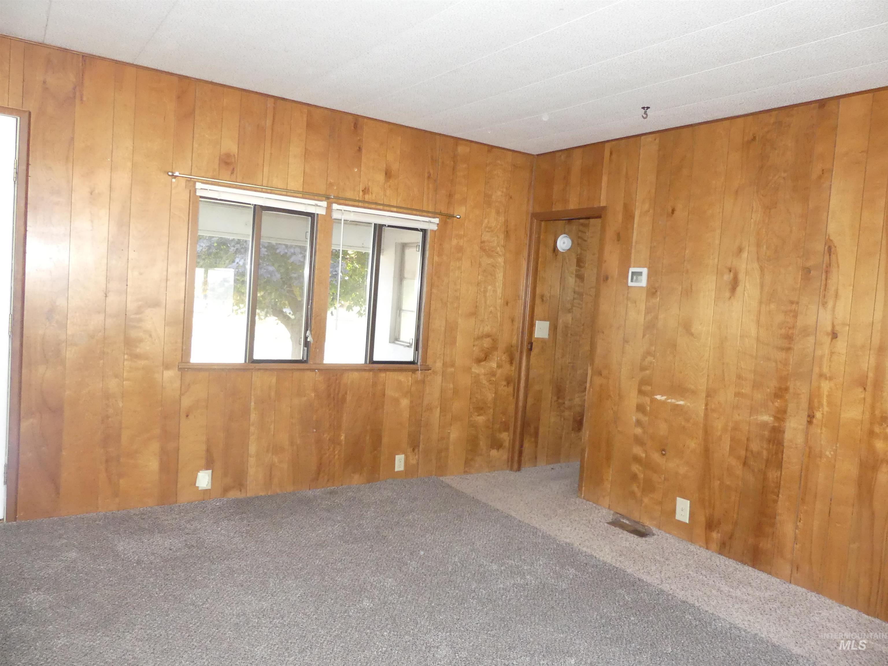 Carpeted empty room with wood walls