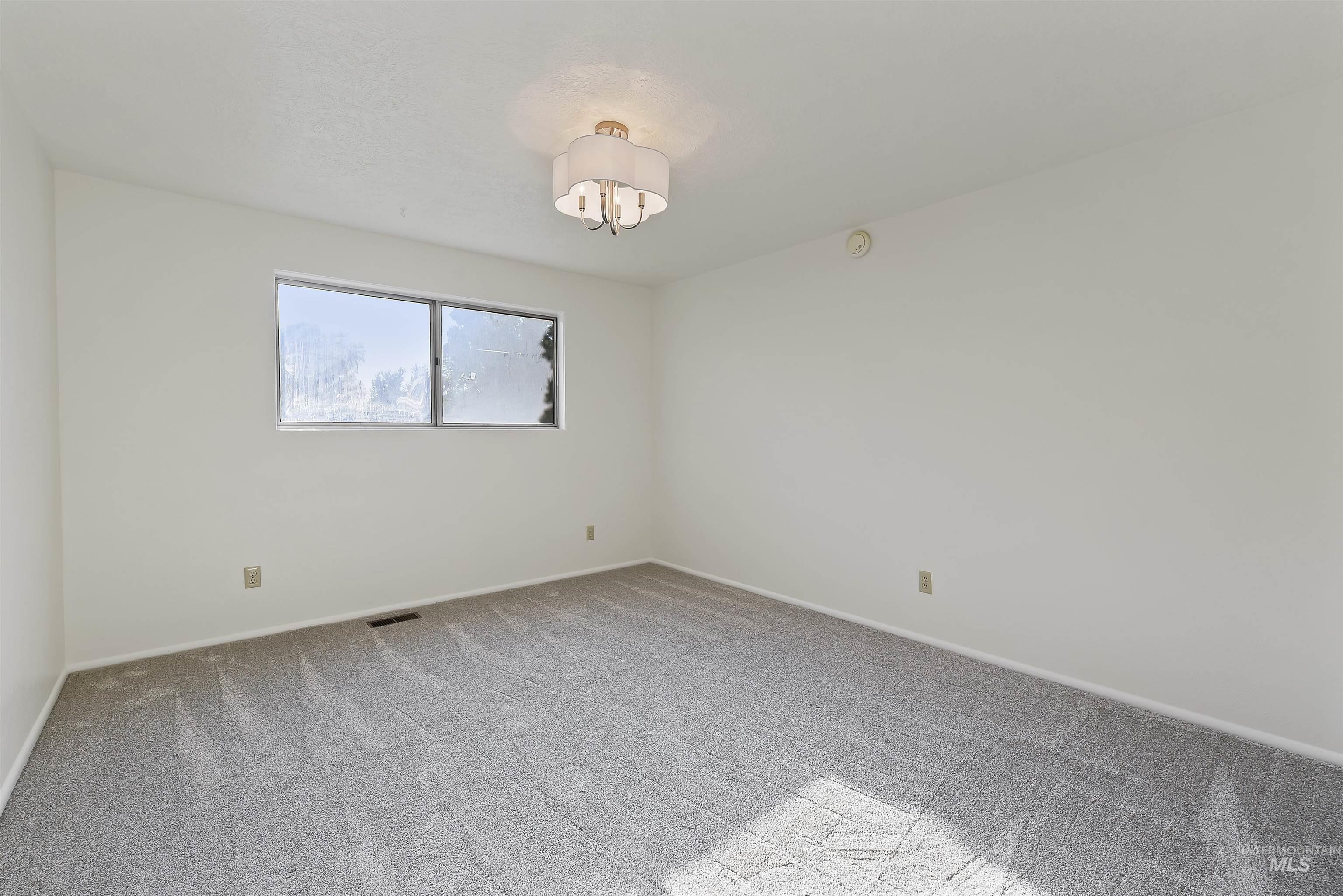 Unfurnished room featuring light colored carpet and baseboards