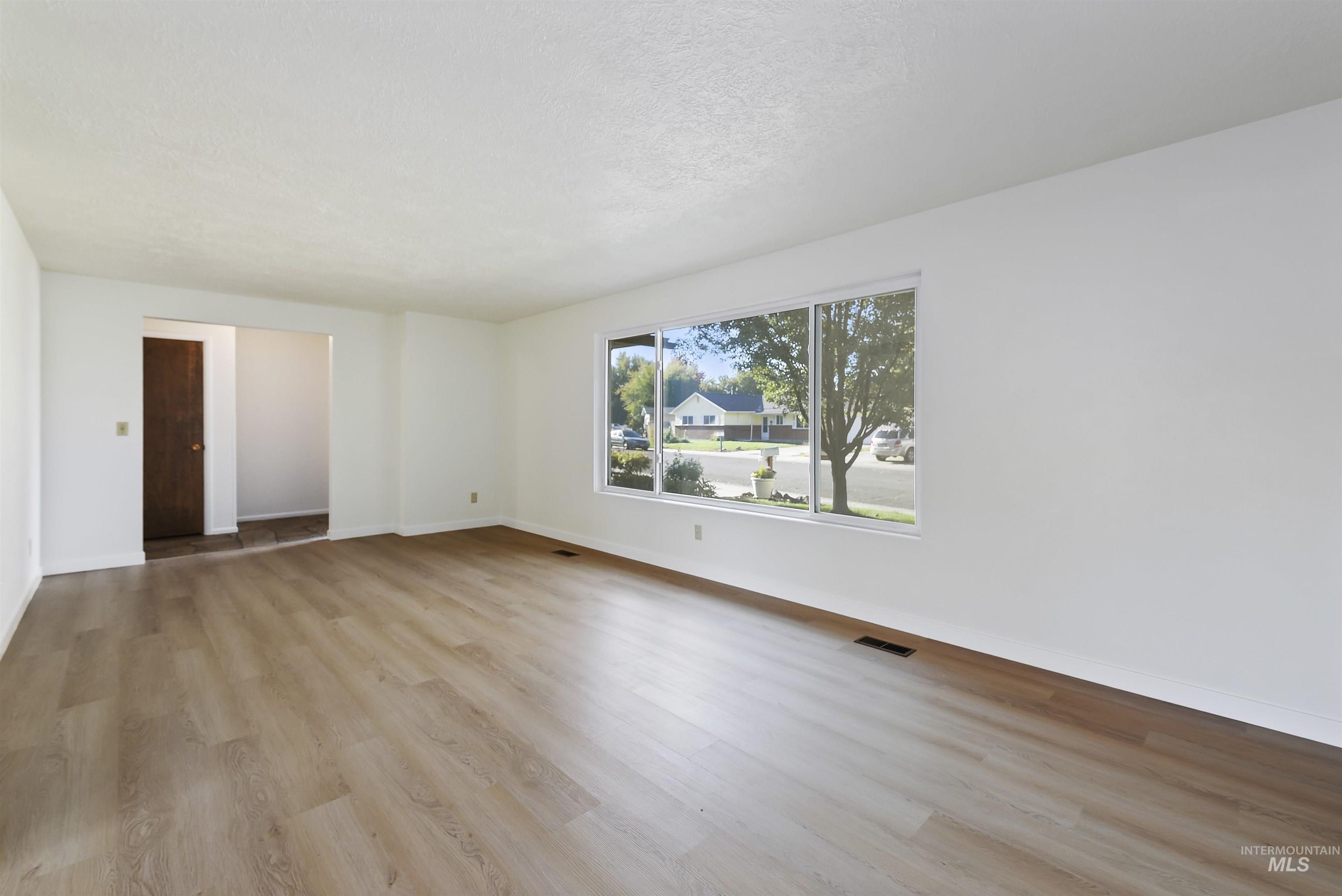 Spare room featuring light wood-style flooring and a textured ceiling