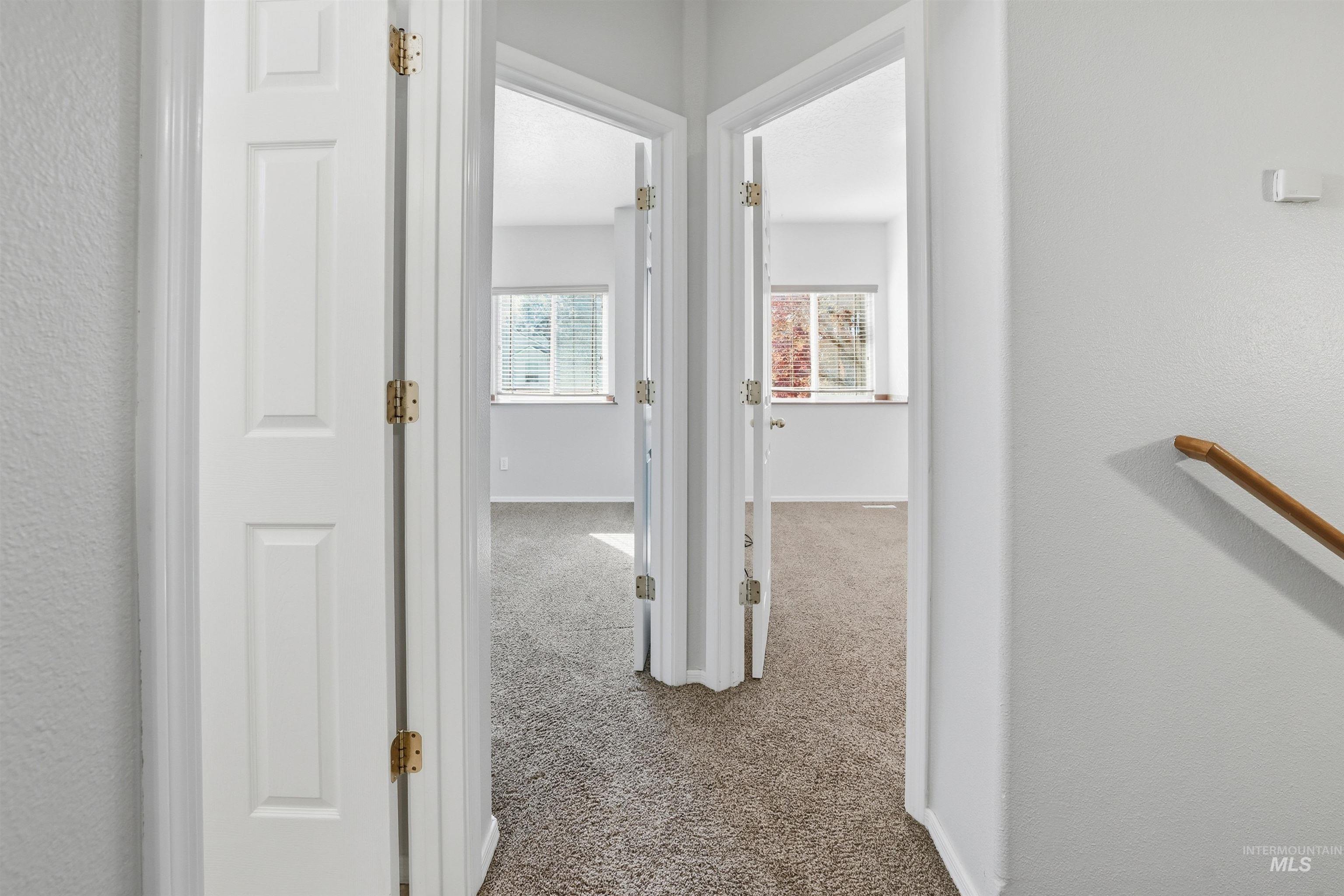 Corridor with light colored carpet and a textured wall