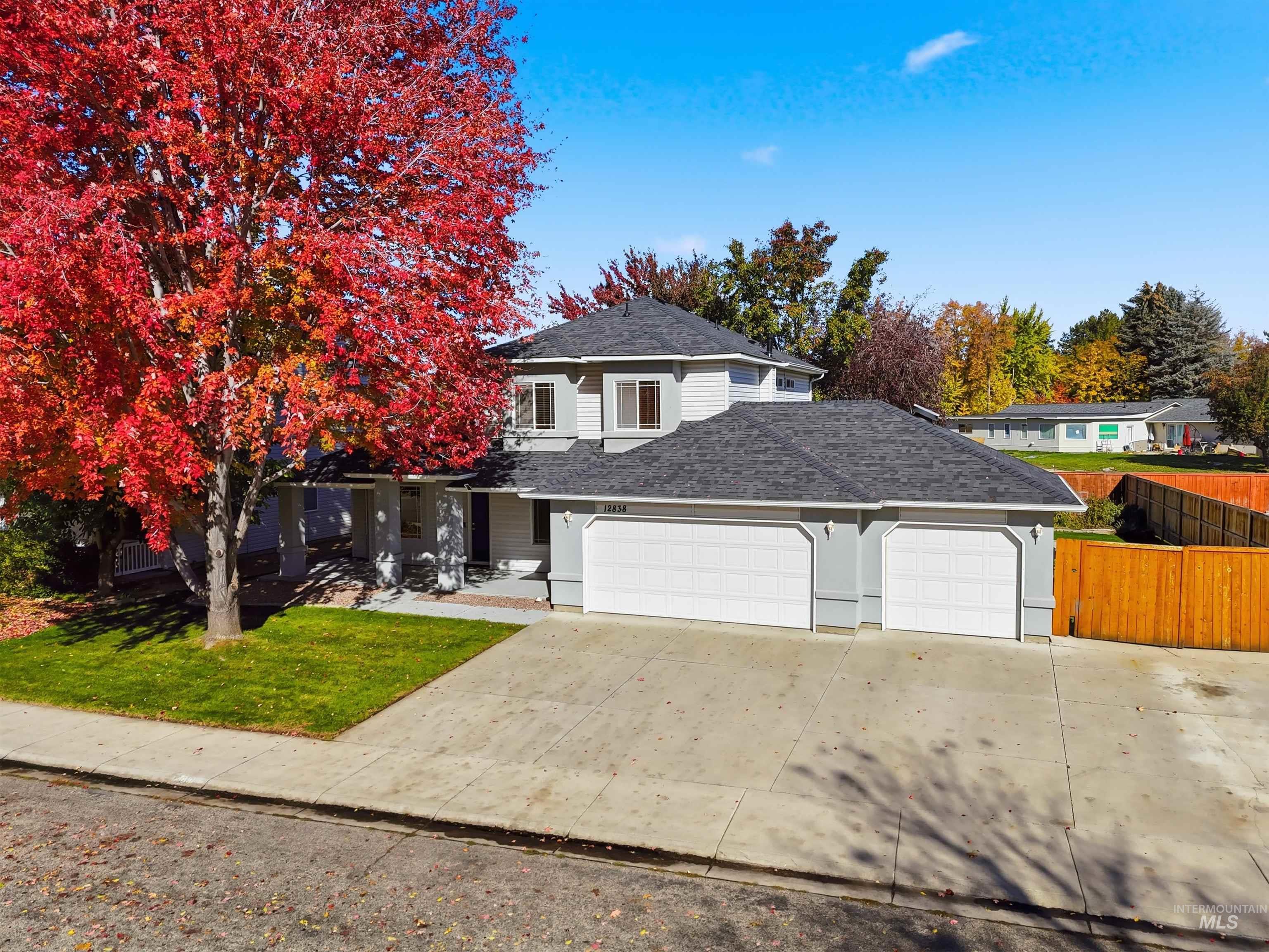 Traditional home with a shingled roof, driveway, an attached garage, and covered porch