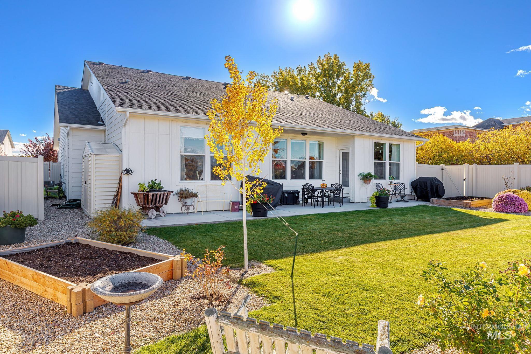 Rear view of house with a vegetable garden, a fenced backyard, and a patio