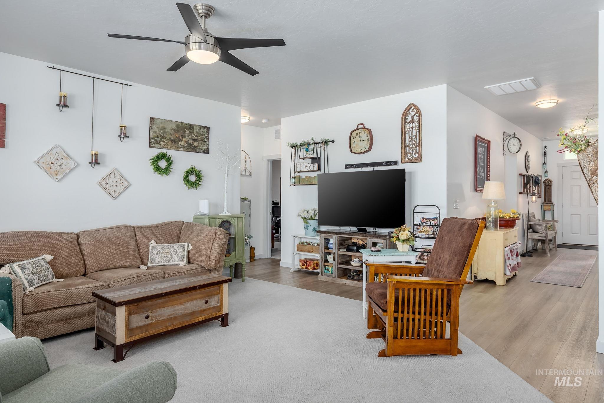 Living area with wood finished floors and ceiling fan