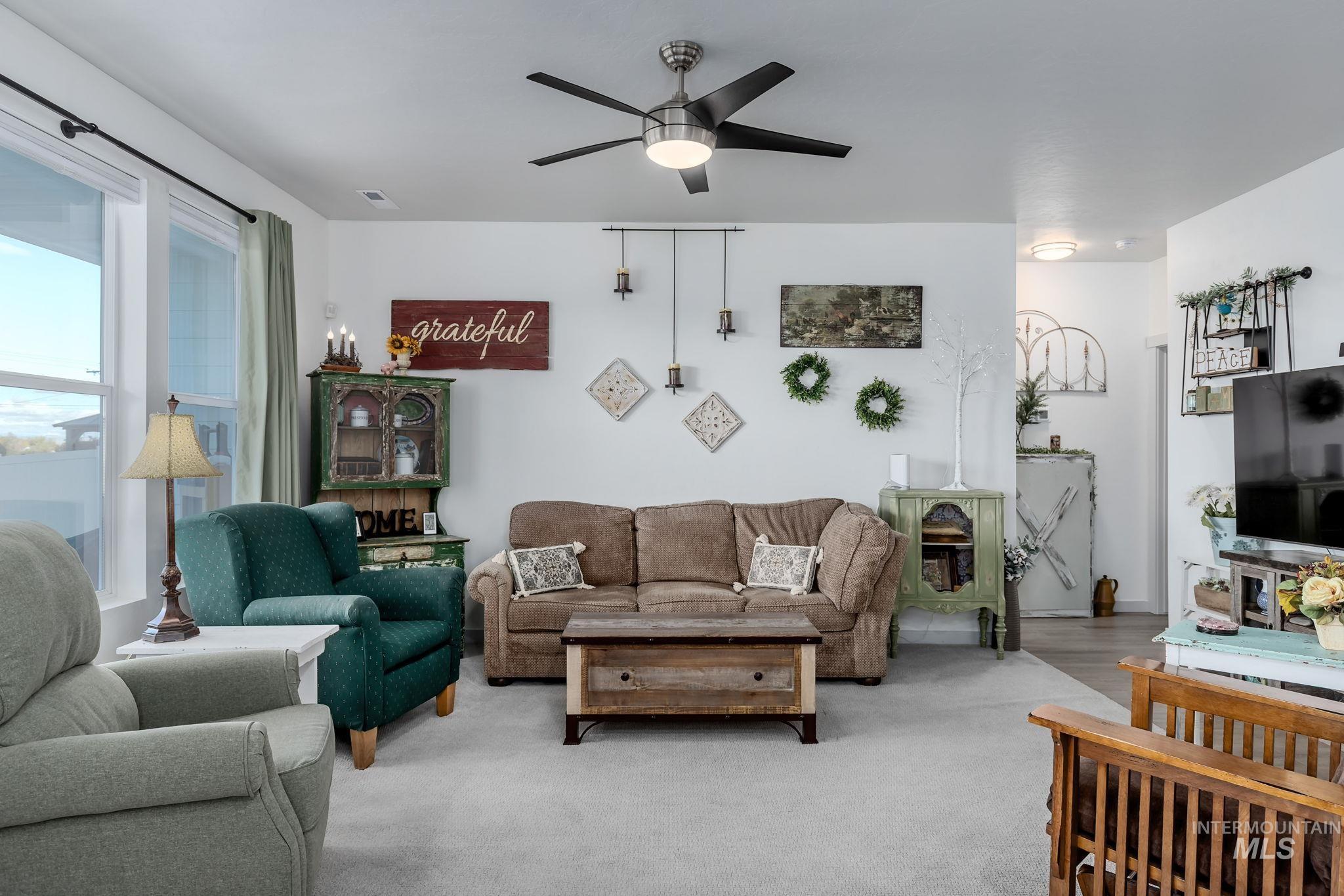 Living room featuring a ceiling fan and carpet flooring