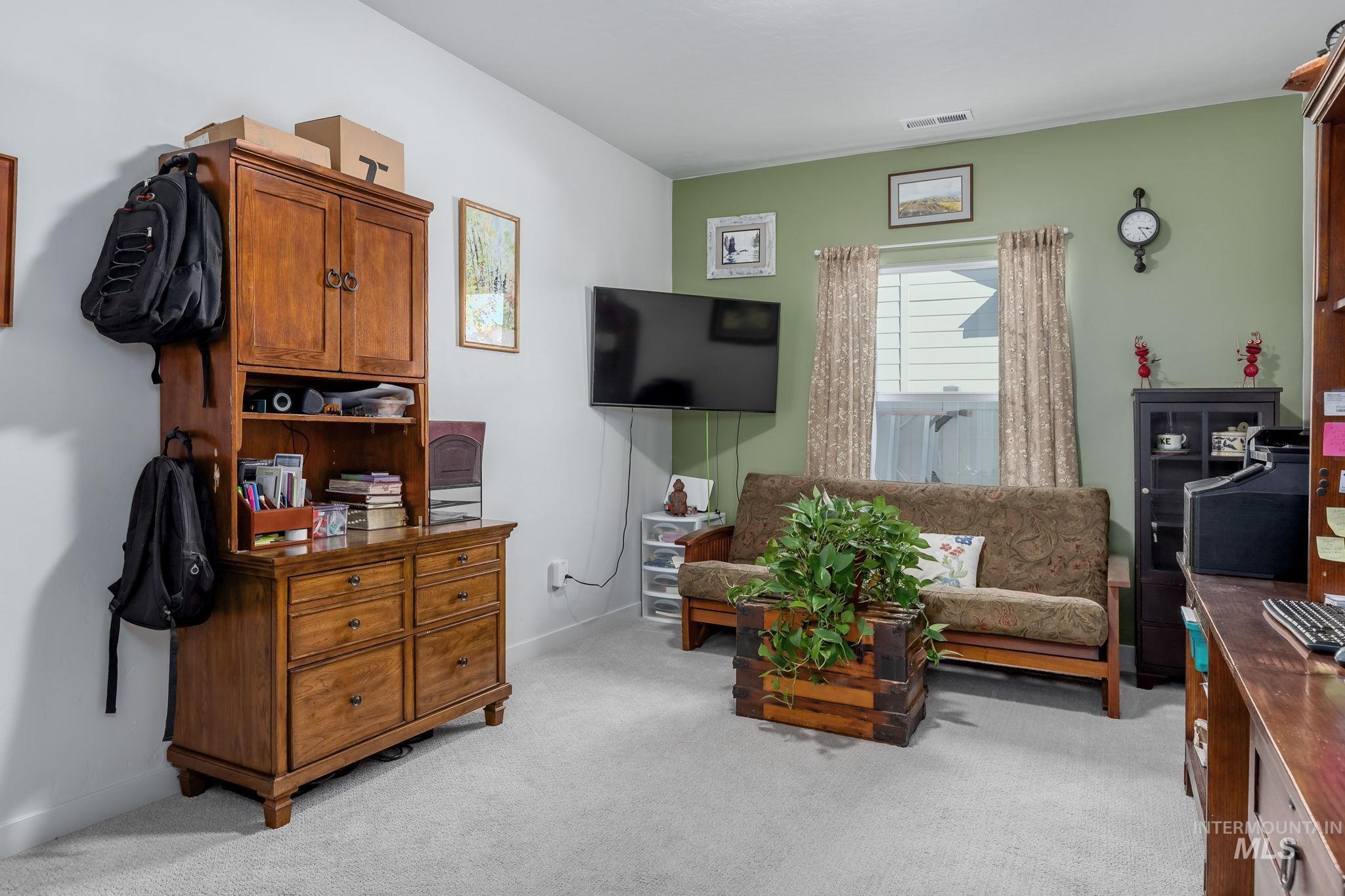Living area featuring light carpet and baseboards