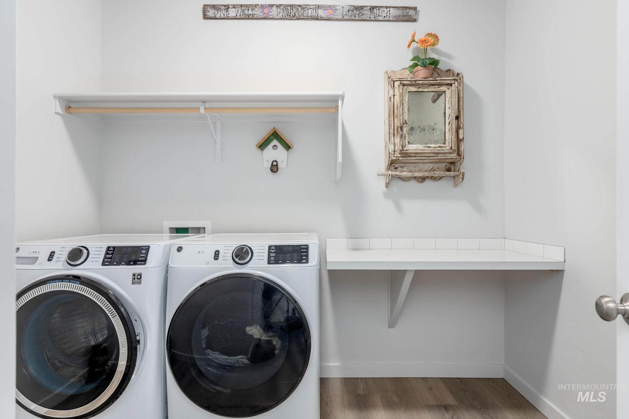 Laundry area with wood finished floors and washer and dryer