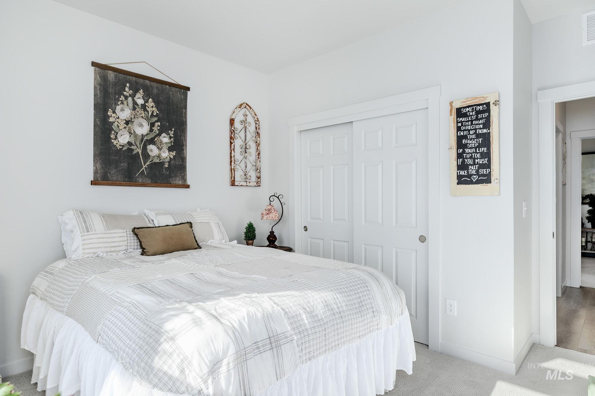 Carpeted bedroom with baseboards and a closet
