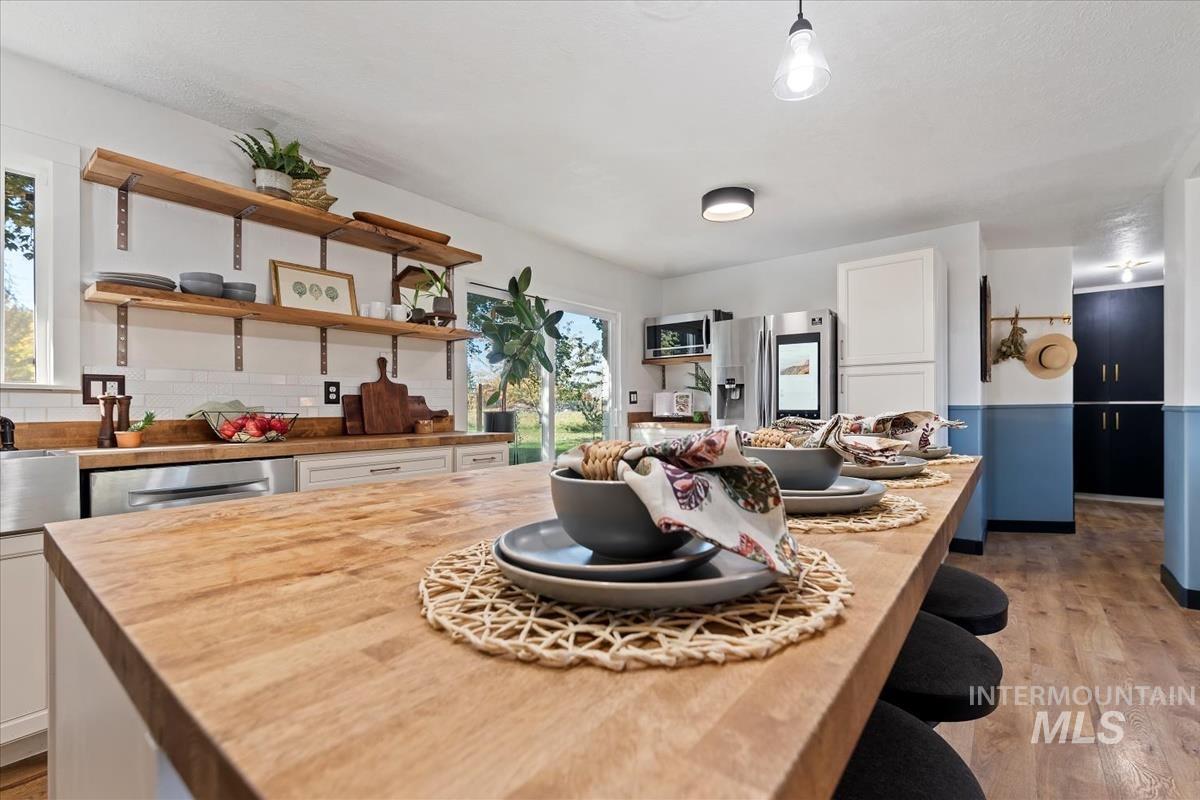Kitchen featuring wooden counters, white cabinetry, light wood-type flooring, and open shelves