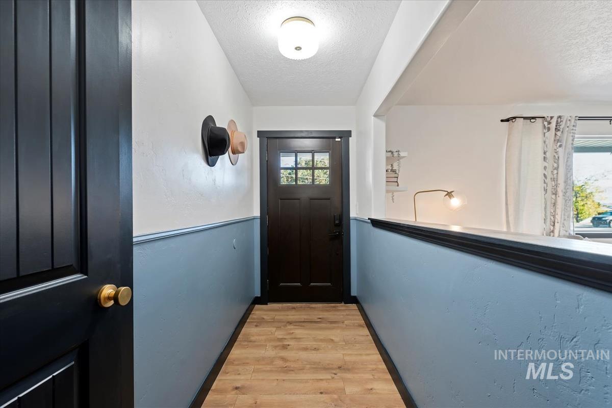 Doorway featuring wood finished floors and a textured ceiling
