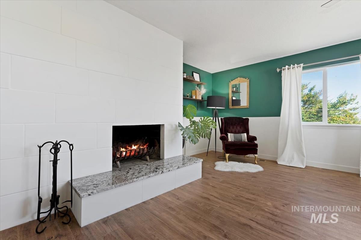 Sitting room with dark wood finished floors and a fireplace
