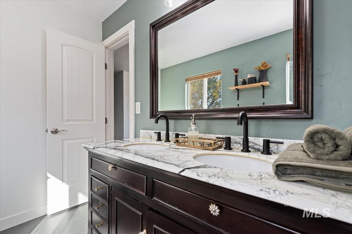 Bathroom featuring double vanity and dark tile patterned floors