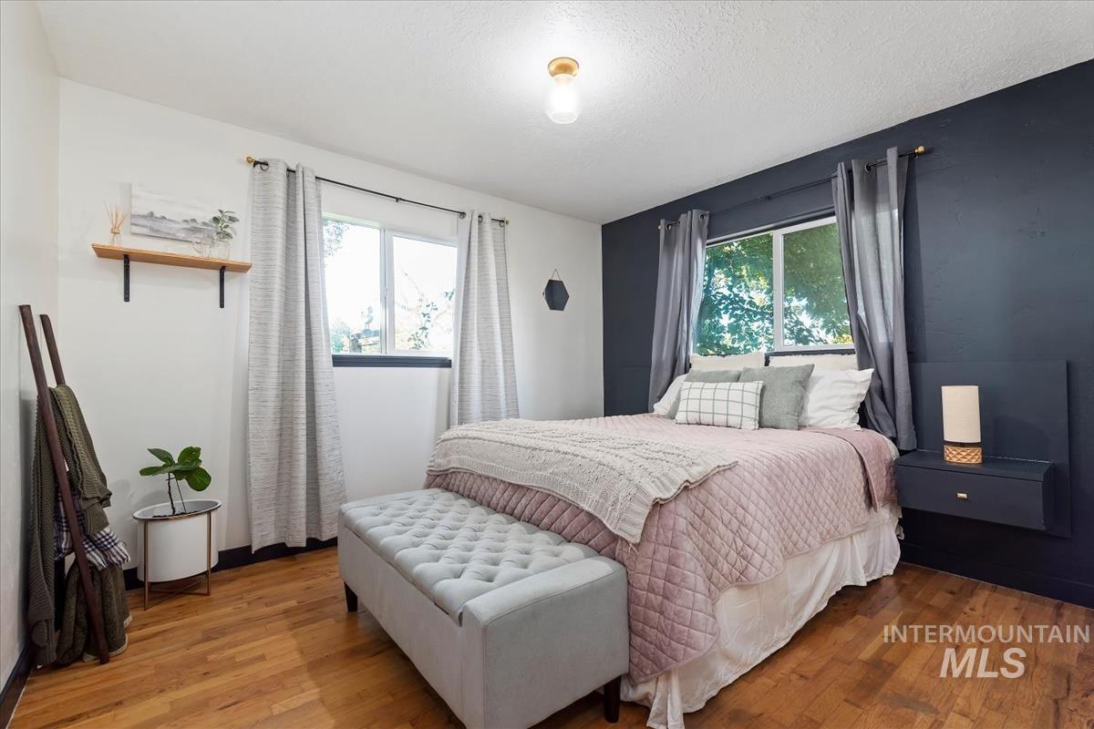 Bedroom with wood finished floors and a textured ceiling