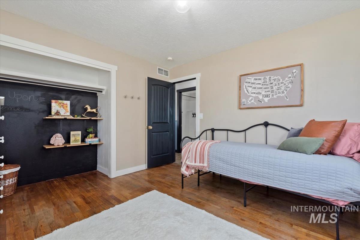 Bedroom featuring a textured ceiling and wood finished floors