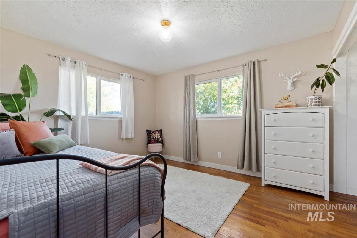 Bedroom featuring light wood-type flooring and a textured ceiling