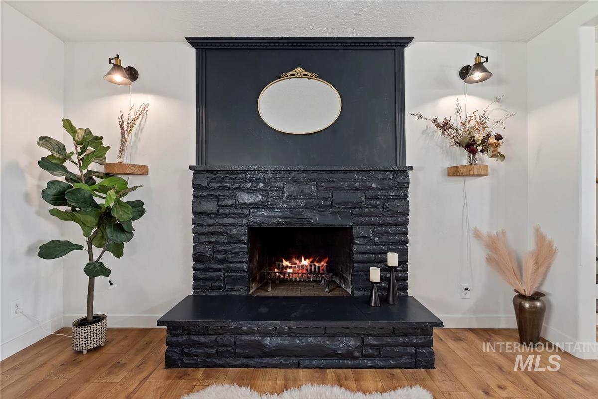 Detailed view of wood finished floors and a warm lit fireplace