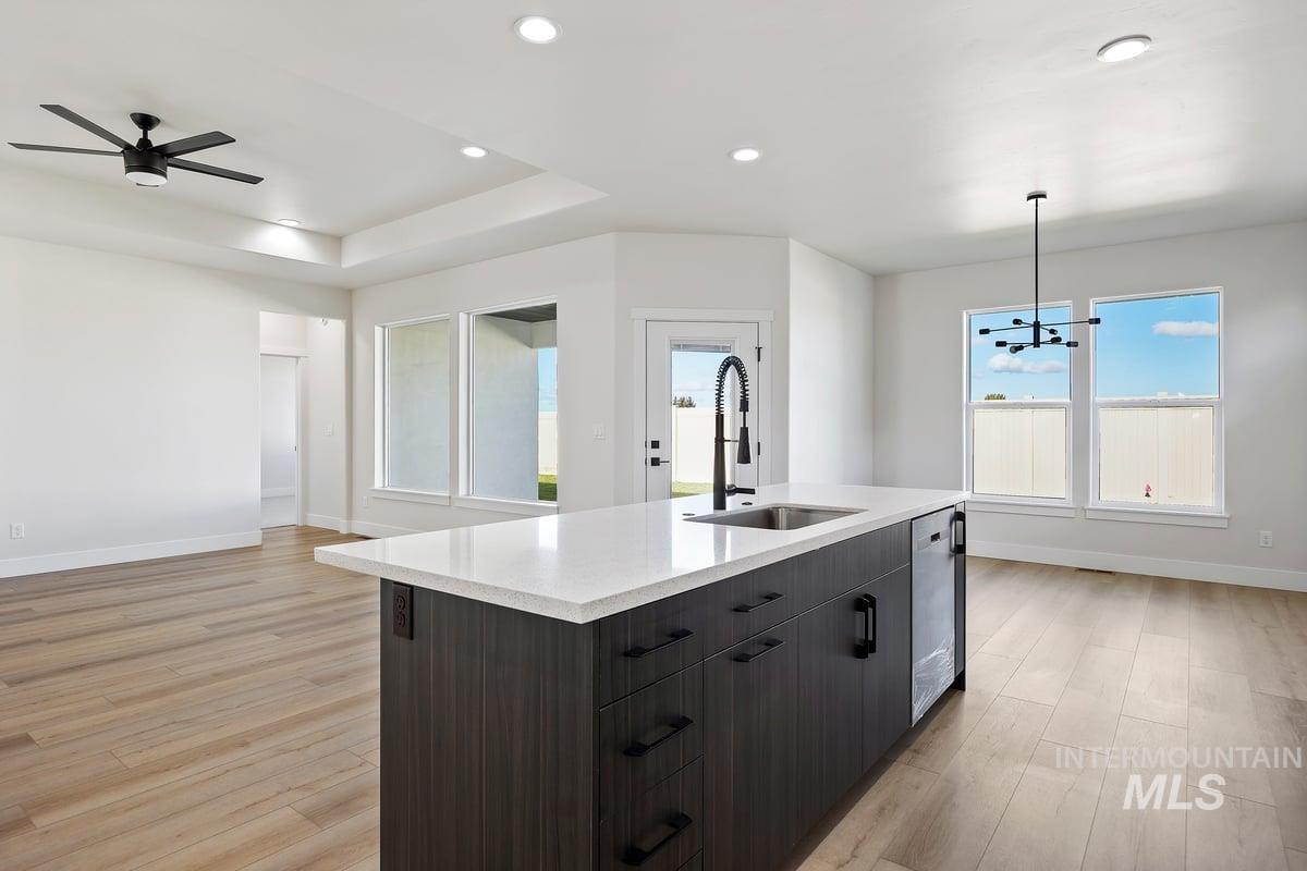 Kitchen featuring pendant lighting, dark brown cabinetry, recessed lighting, modern cabinets, and an island with sink