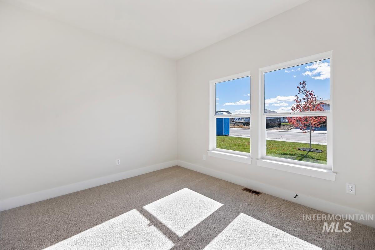 Spare room with carpet and baseboards