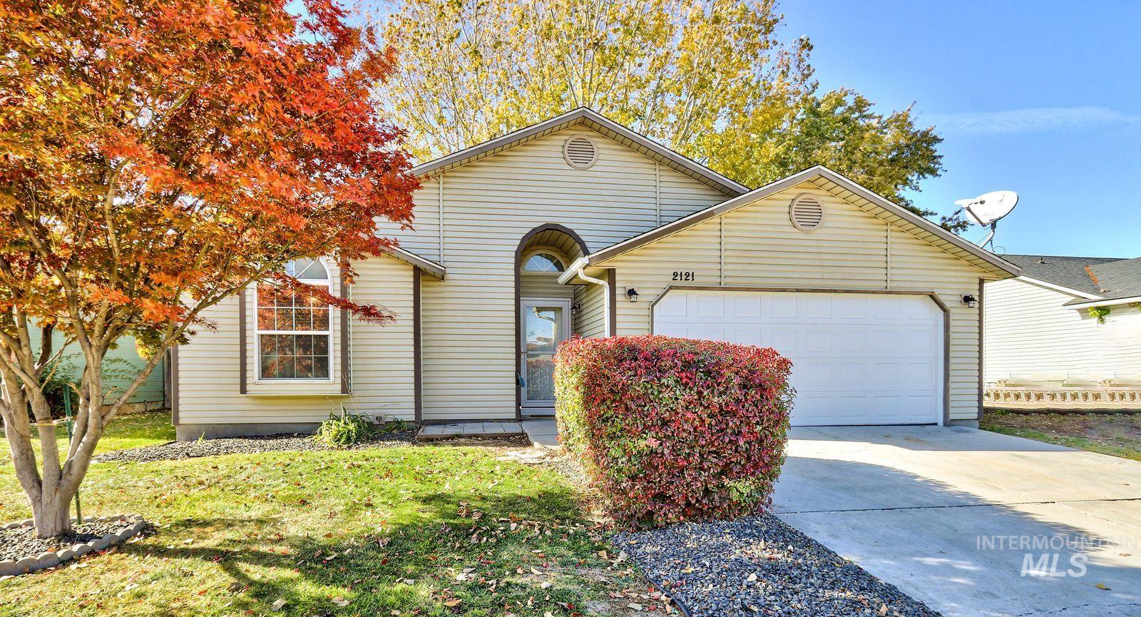 View of front of house featuring concrete driveway, an attached garage, and a front yard