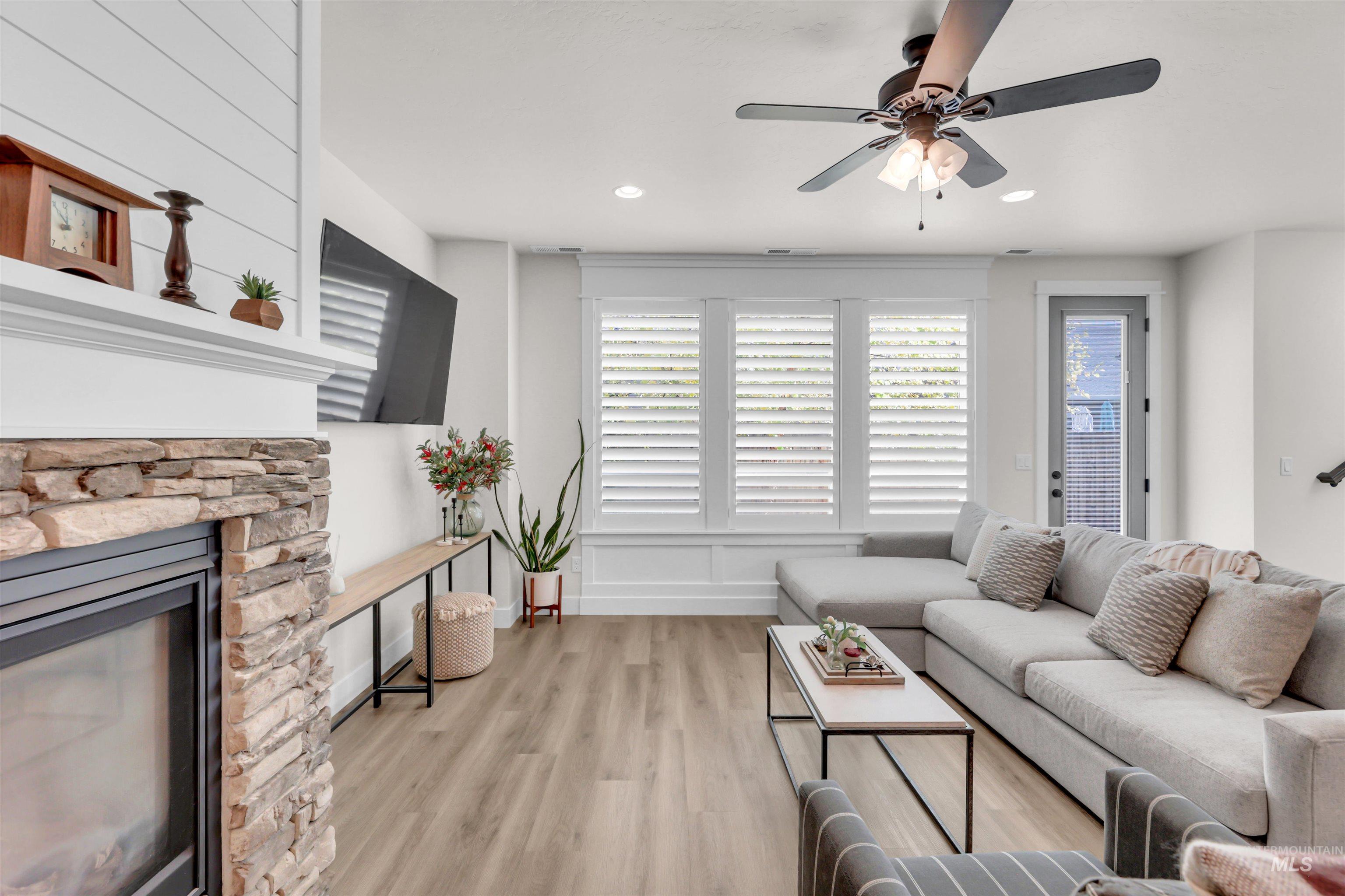 Living area with wood finished floors, a fireplace, ceiling fan, and recessed lighting