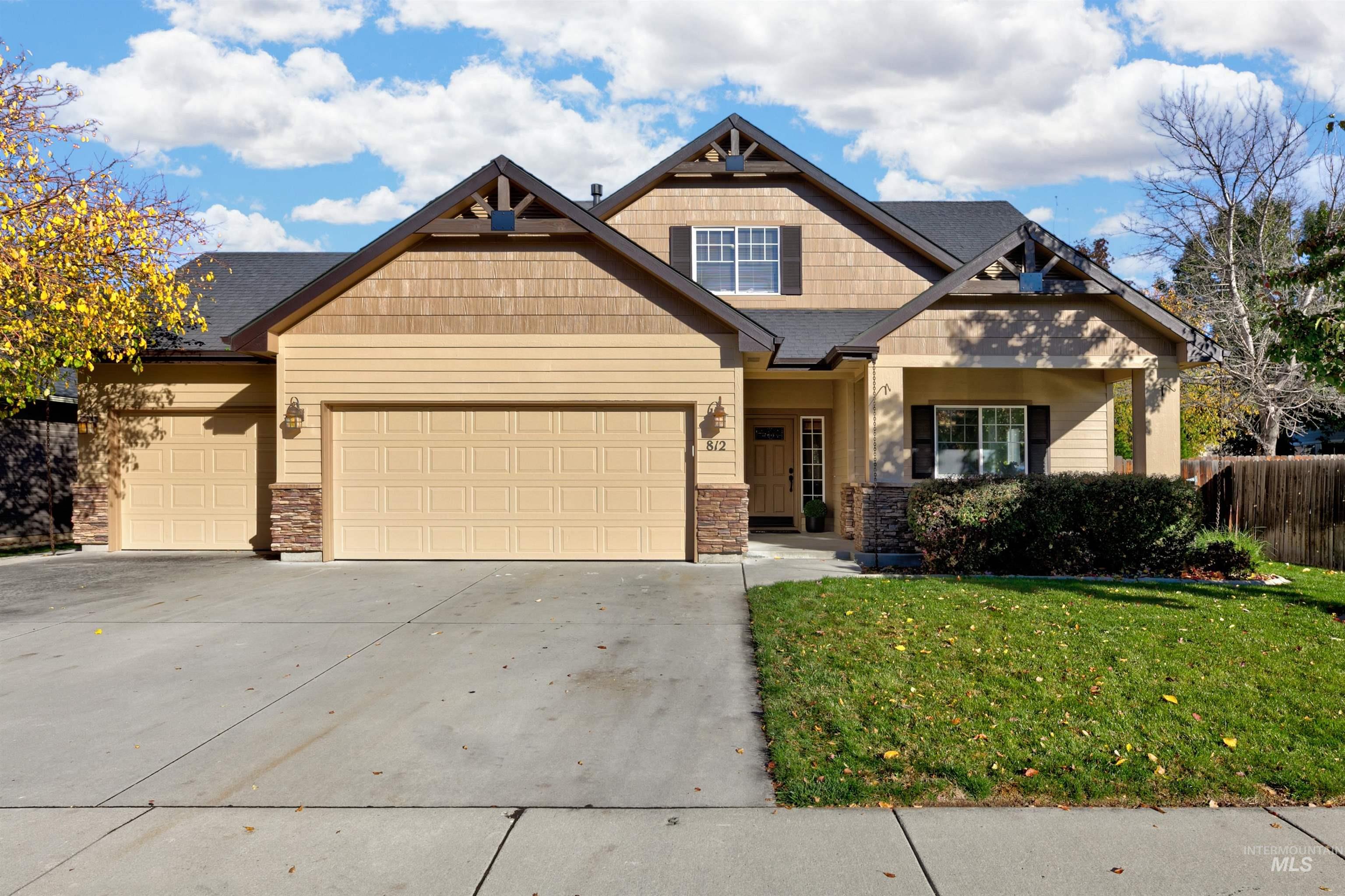 Craftsman-style home featuring concrete driveway, stone siding, and a garage