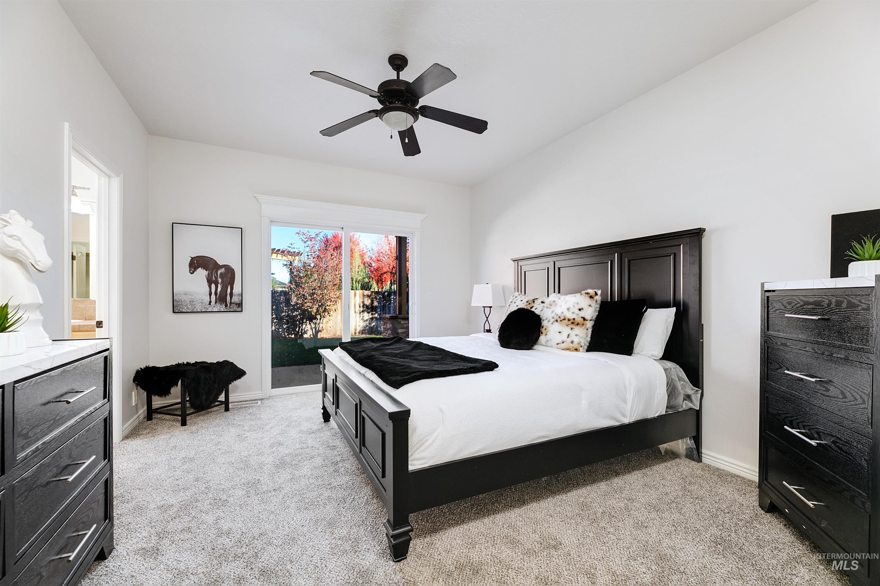 Bedroom featuring light carpet, access to exterior, and a ceiling fan
