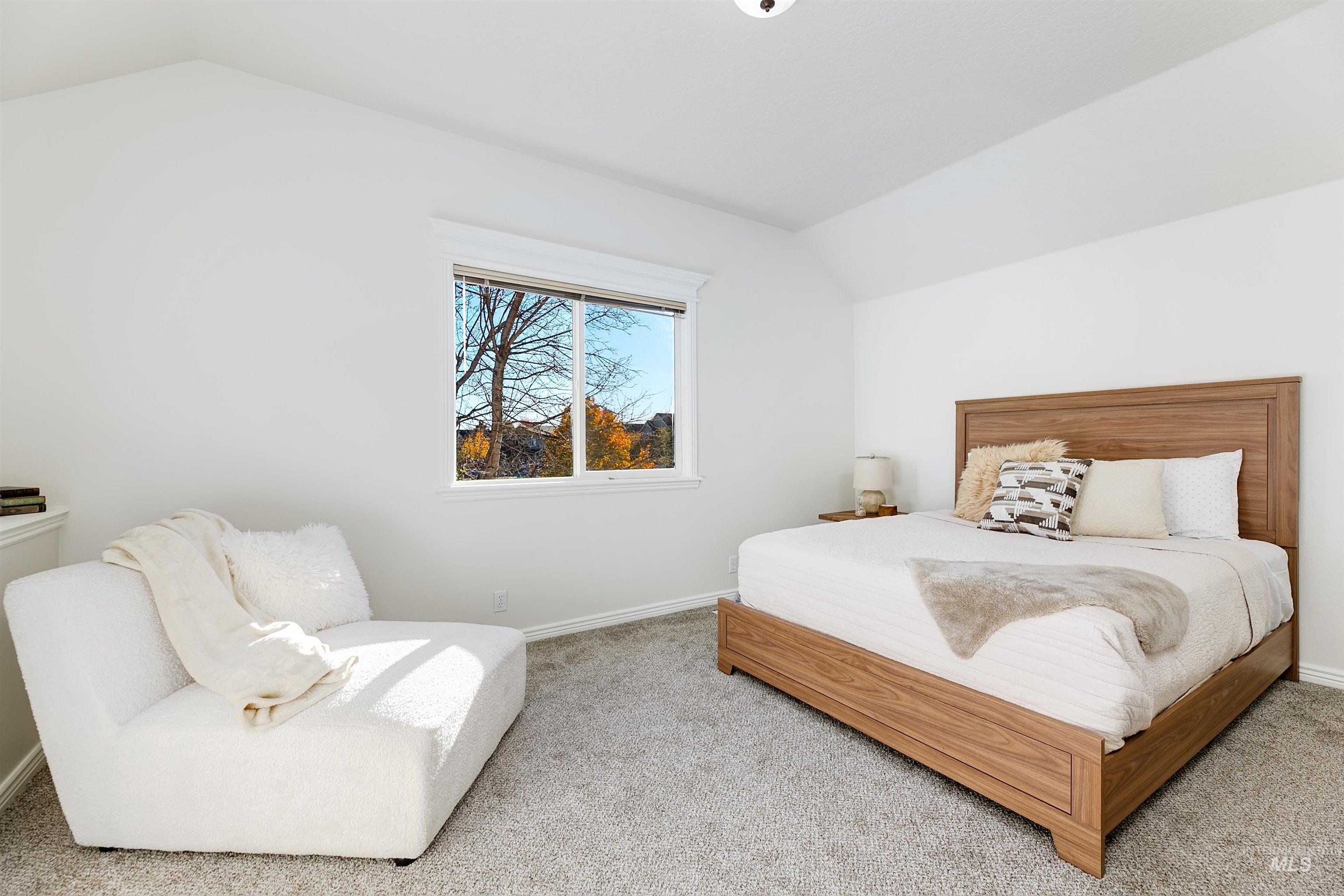 Bedroom featuring vaulted ceiling and carpet