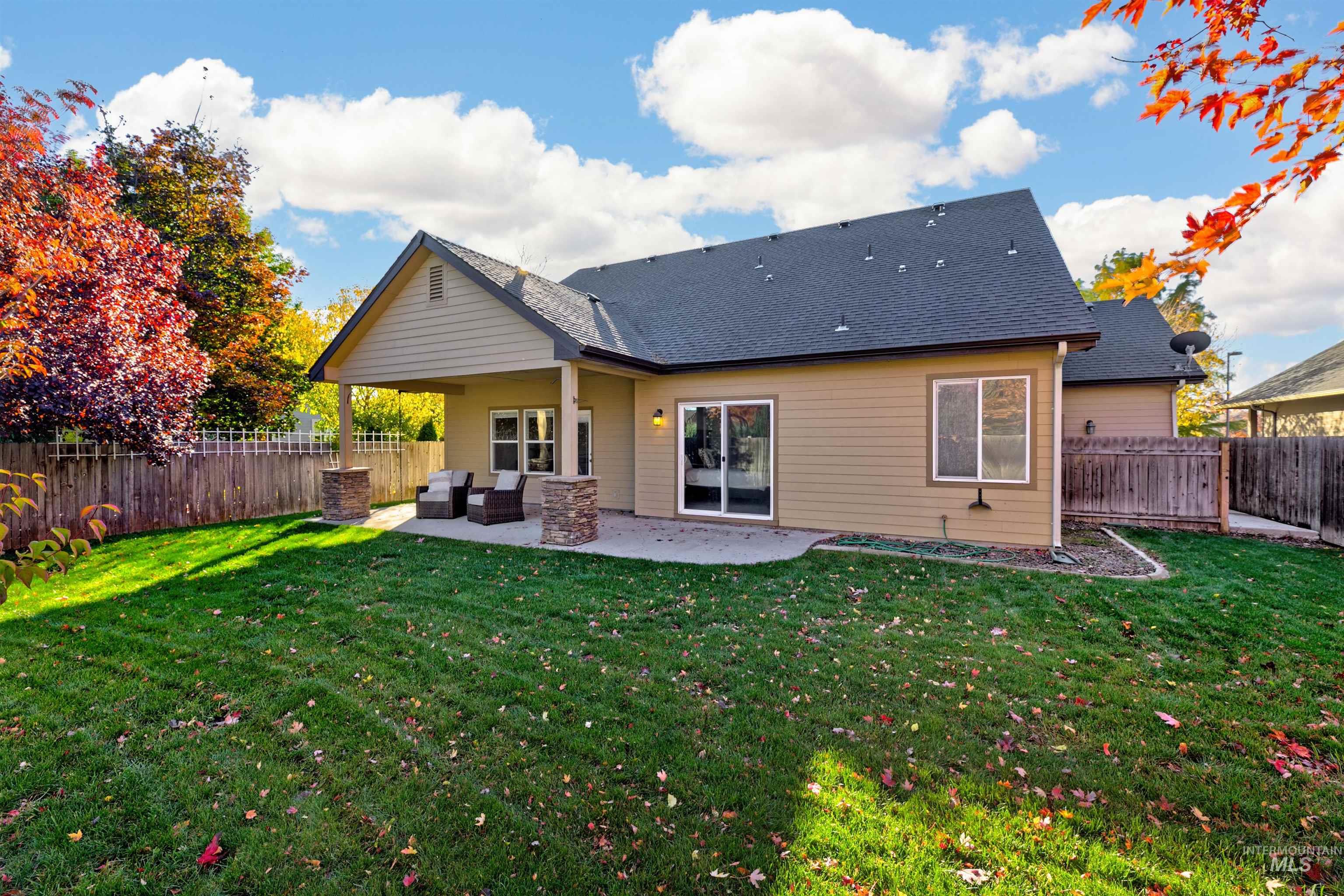 Rear view of house featuring a fenced backyard, a patio, outdoor lounge area, and a shingled roof