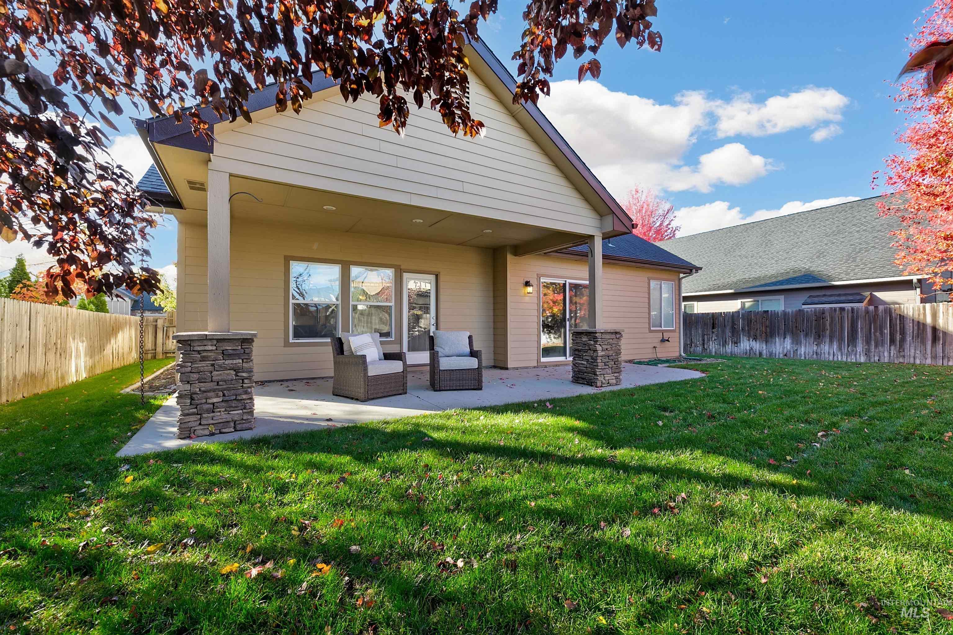 Rear view of property with a fenced backyard and a patio area