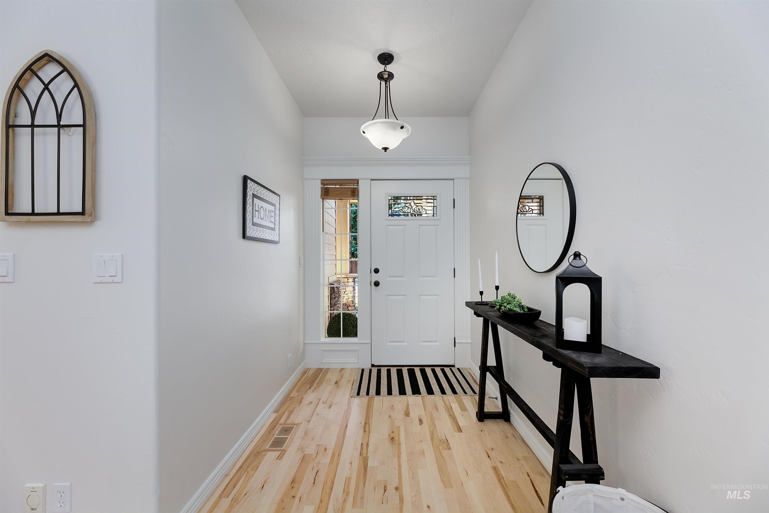 Foyer with light wood-style flooring and baseboards