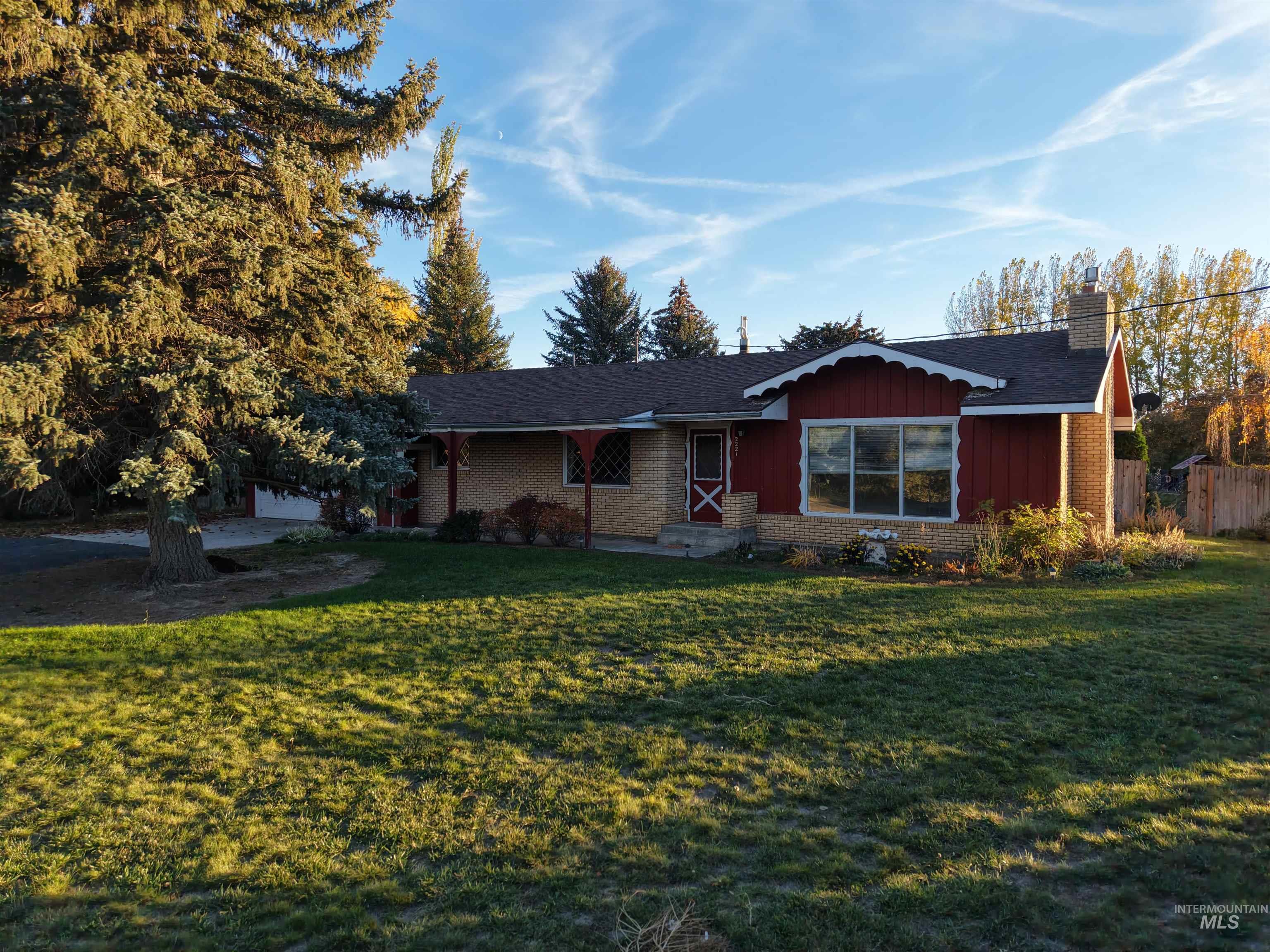 Ranch-style house with board and batten siding, a front yard, brick siding, and a chimney