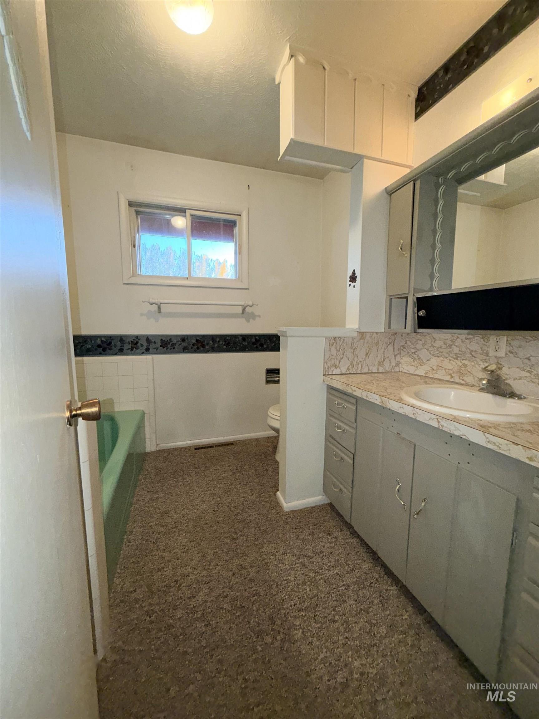 Full bathroom featuring a bath, vanity, and a textured ceiling