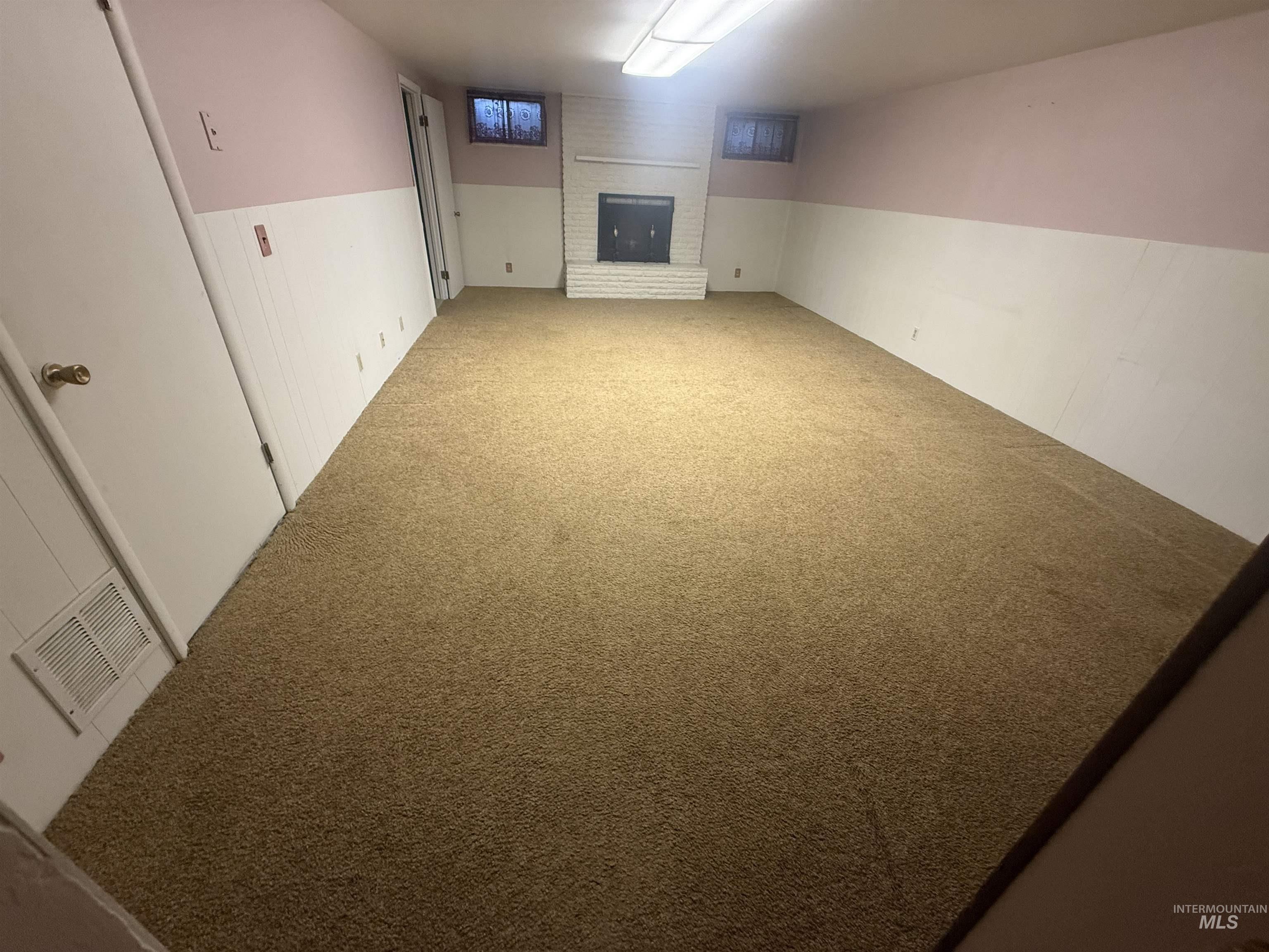 Finished below grade area featuring carpet floors and a brick fireplace