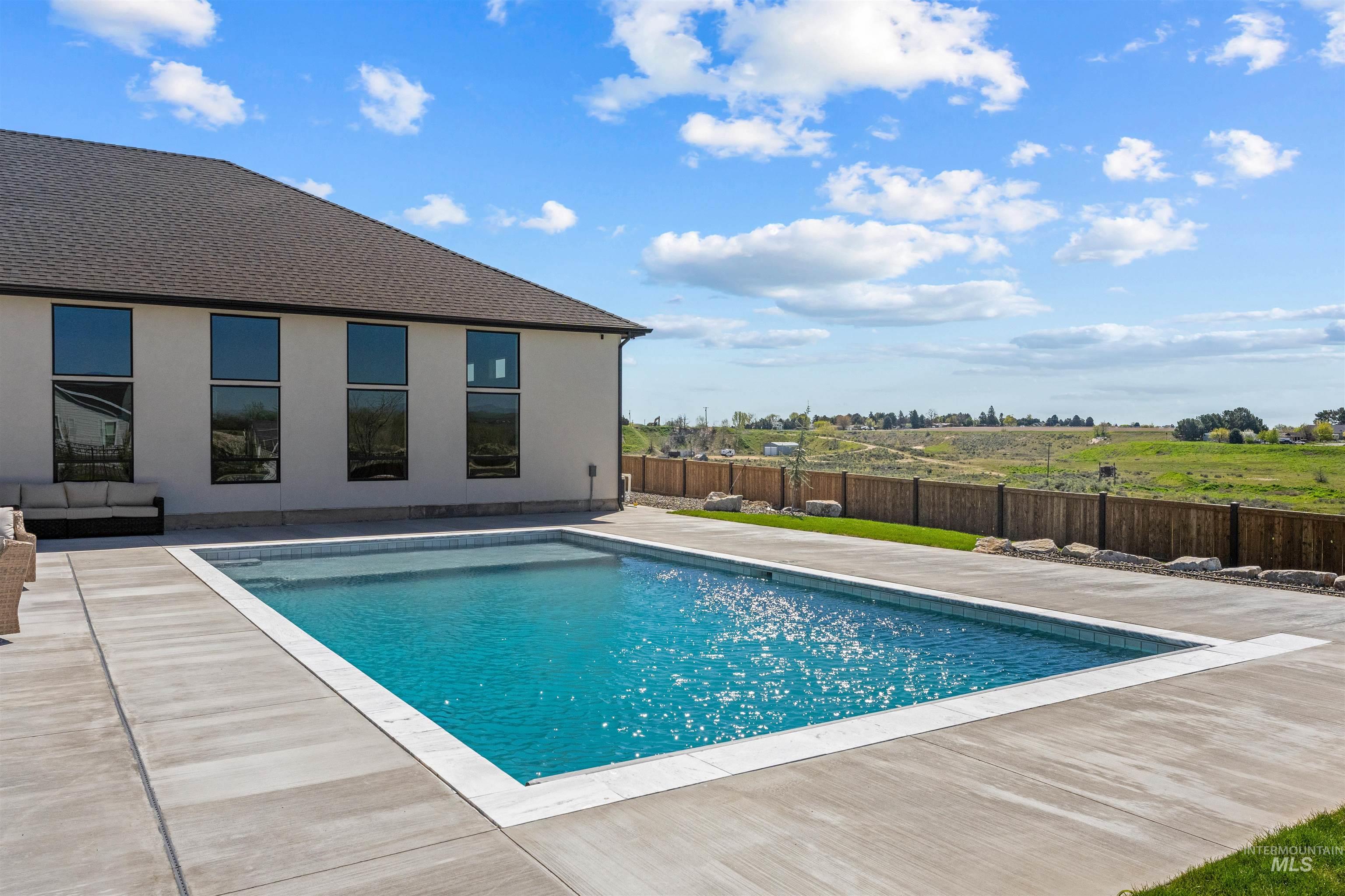 View of swimming pool with a patio area and a fenced backyard