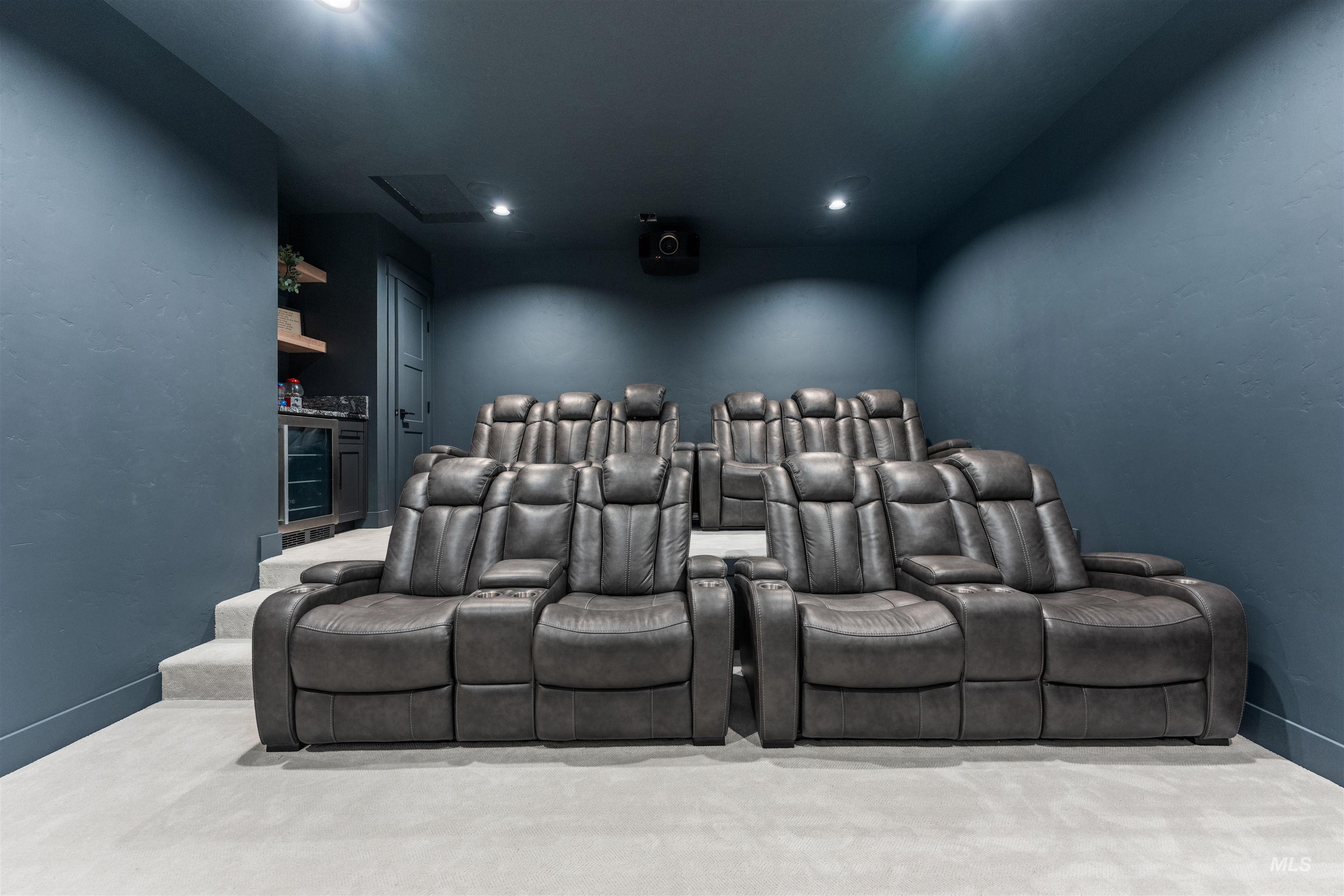 Carpeted home theater room with a textured wall and recessed lighting