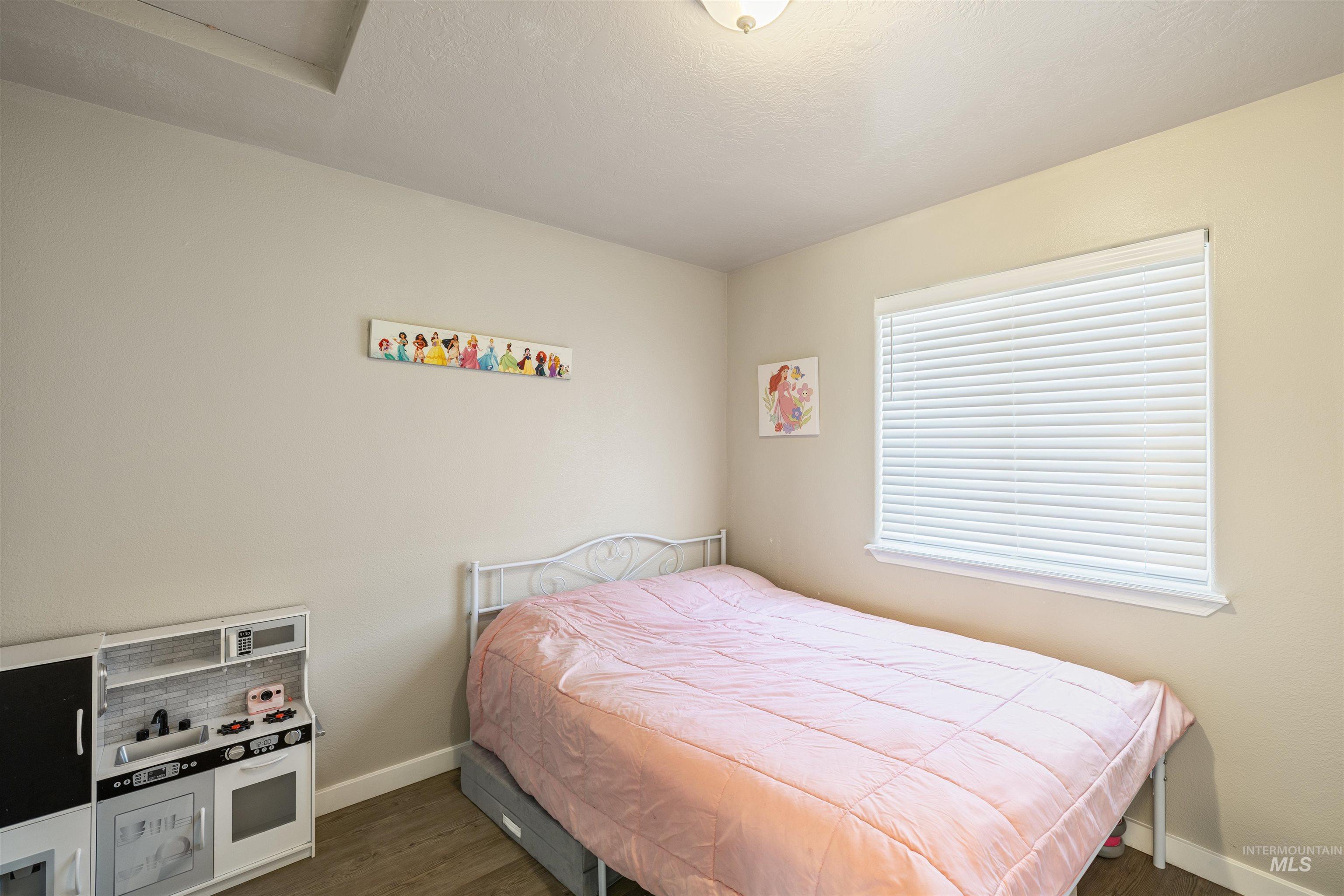 Bedroom with baseboards and dark wood finished floors