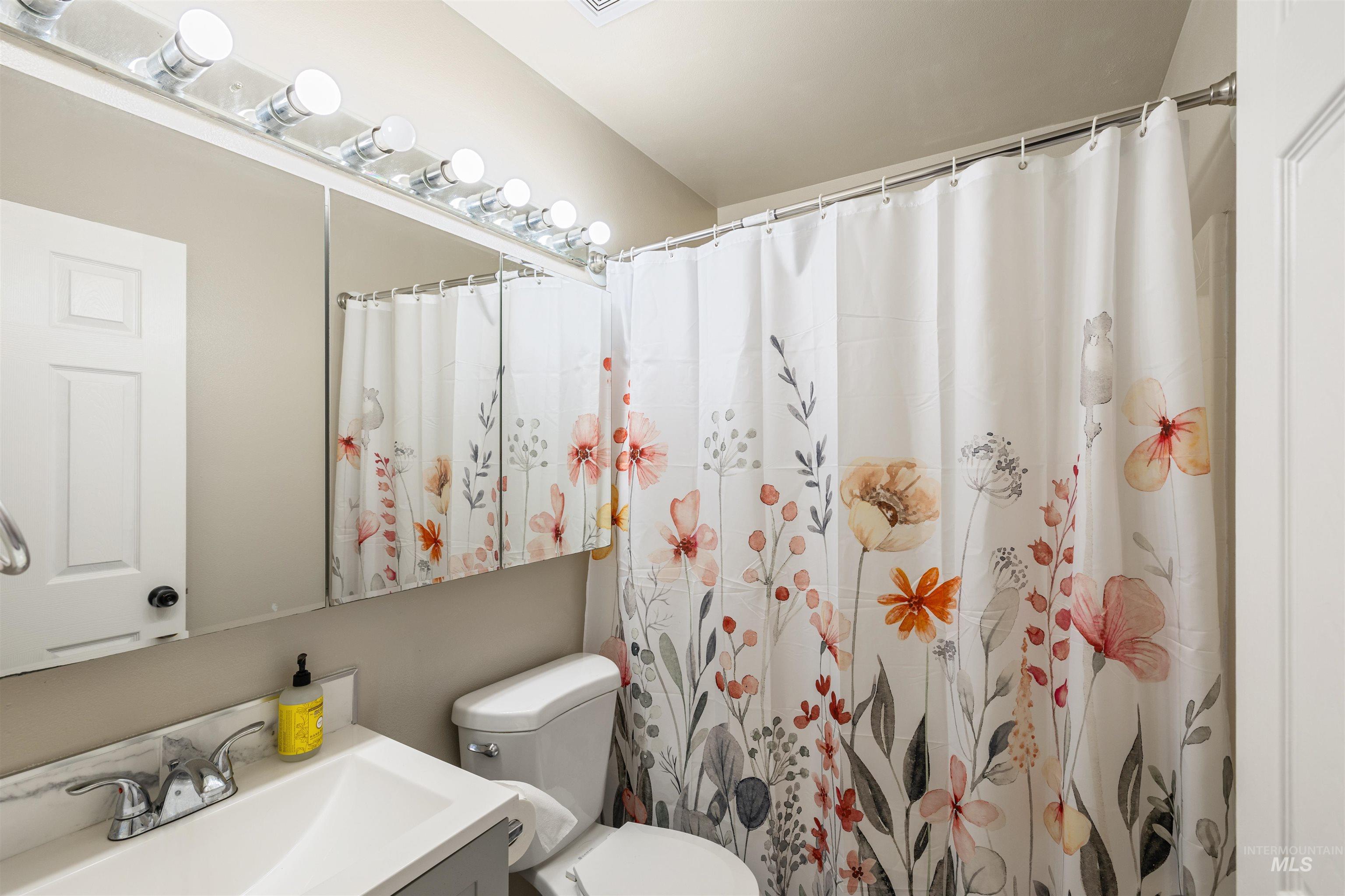 Bathroom with vanity and curtained shower