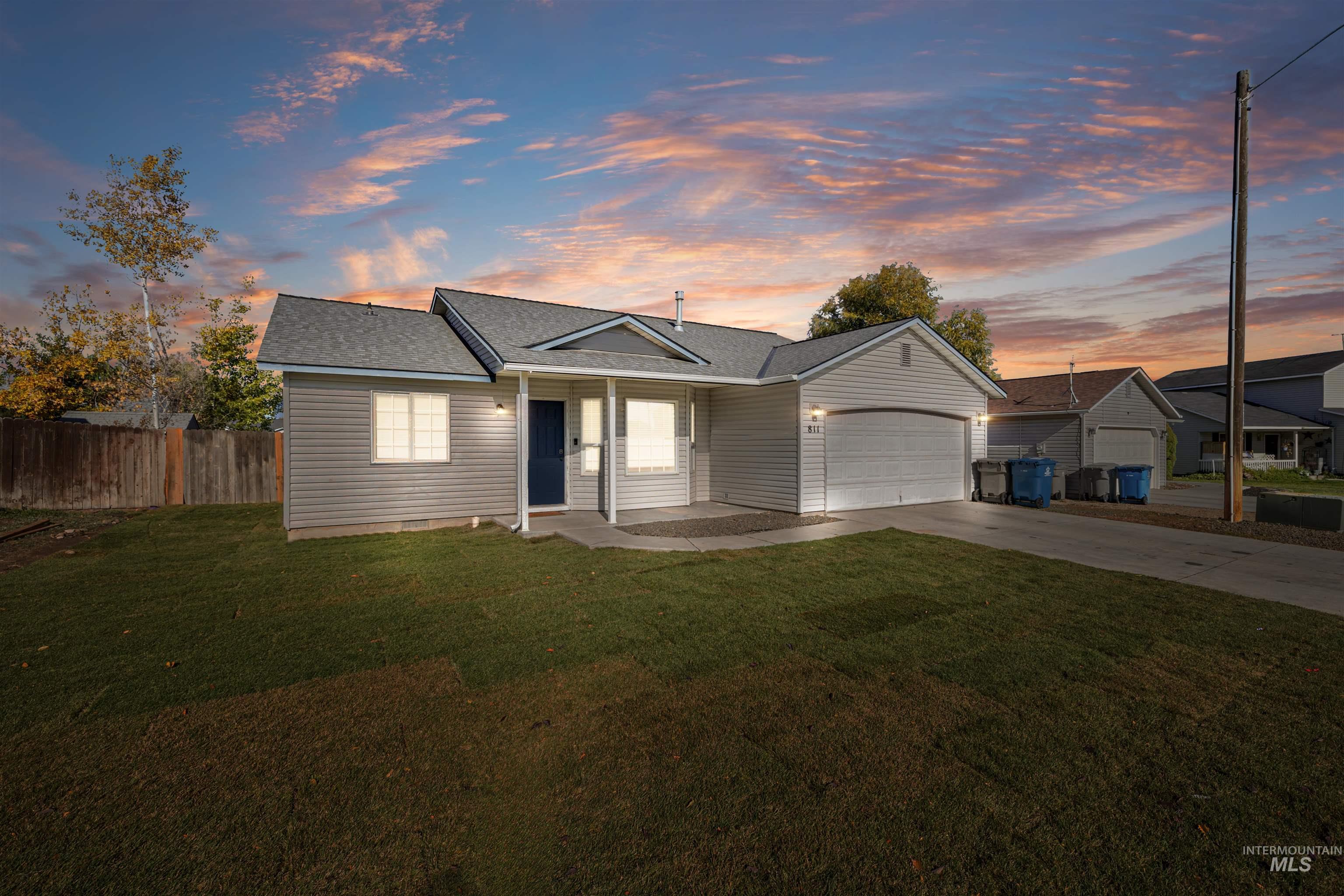 View of front facade featuring concrete driveway, a garage, and roof with shingles