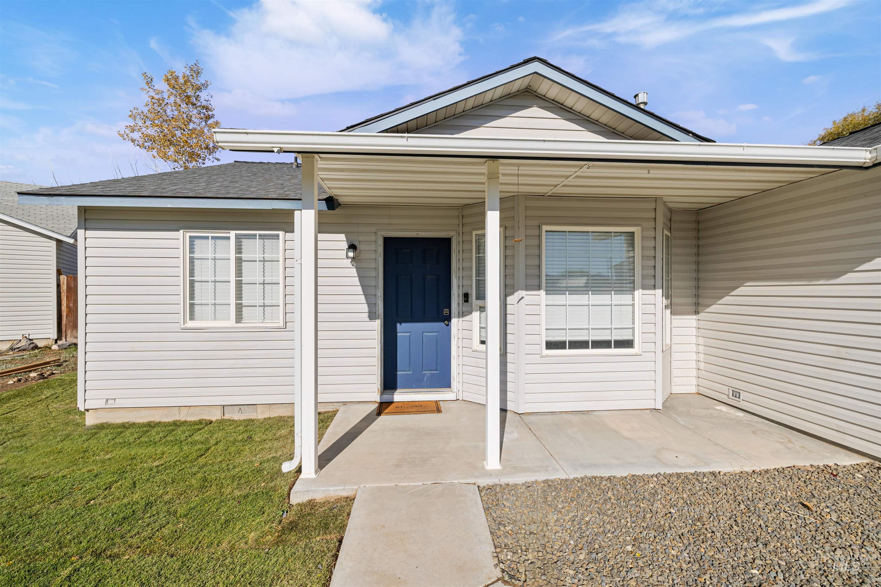 Property entrance featuring a porch, a yard, and roof with shingles
