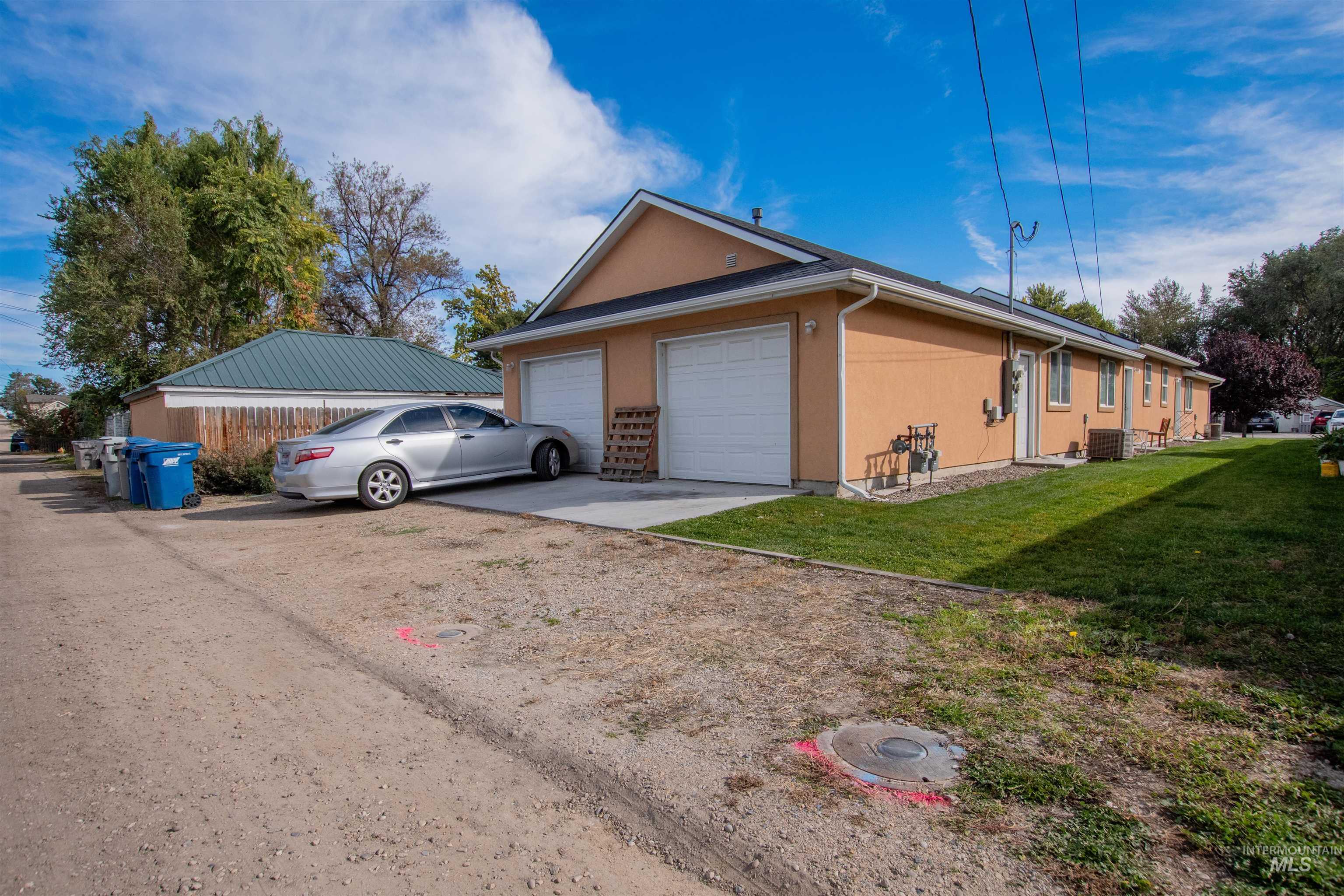 View of side of property featuring driveway, a yard, a garage, and stucco siding