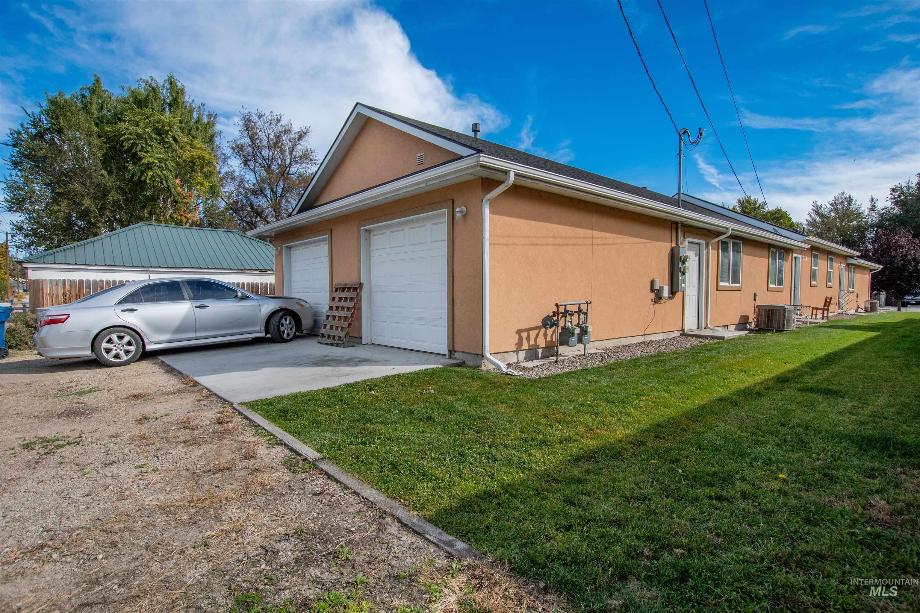 View of property exterior featuring a lawn, an attached garage, and concrete driveway