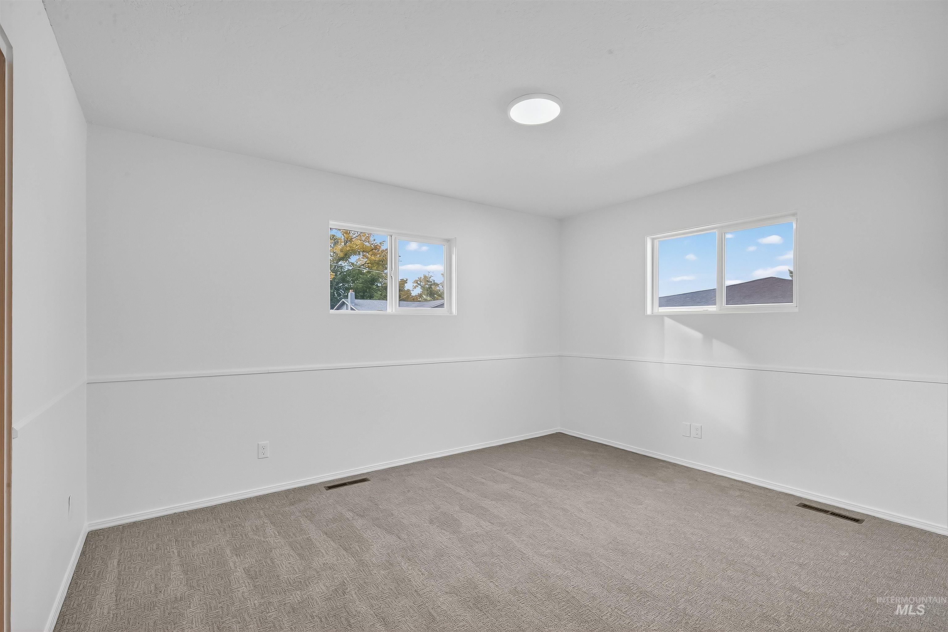 Empty room with light carpet and baseboards
