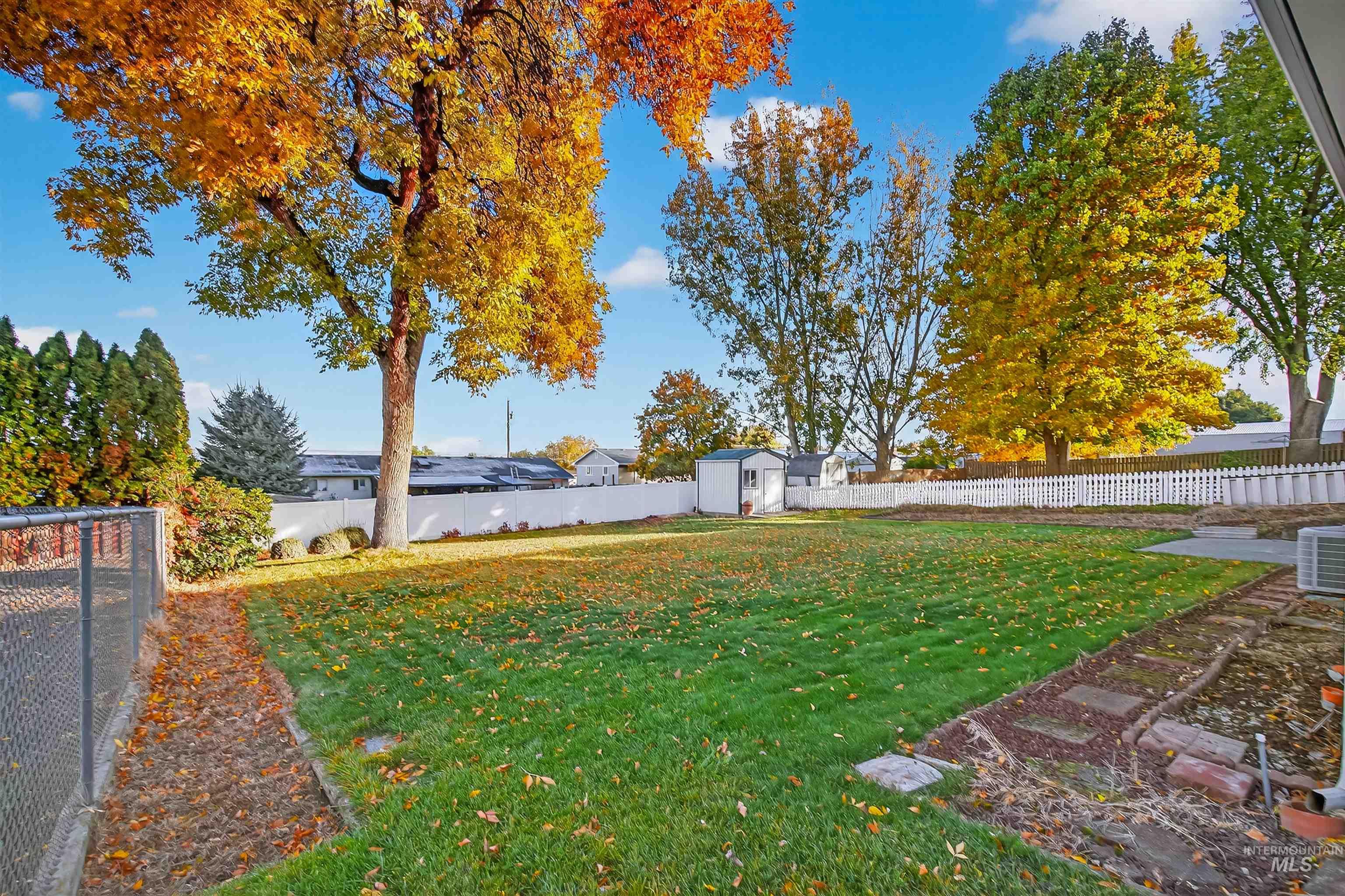 Fenced backyard featuring a shed