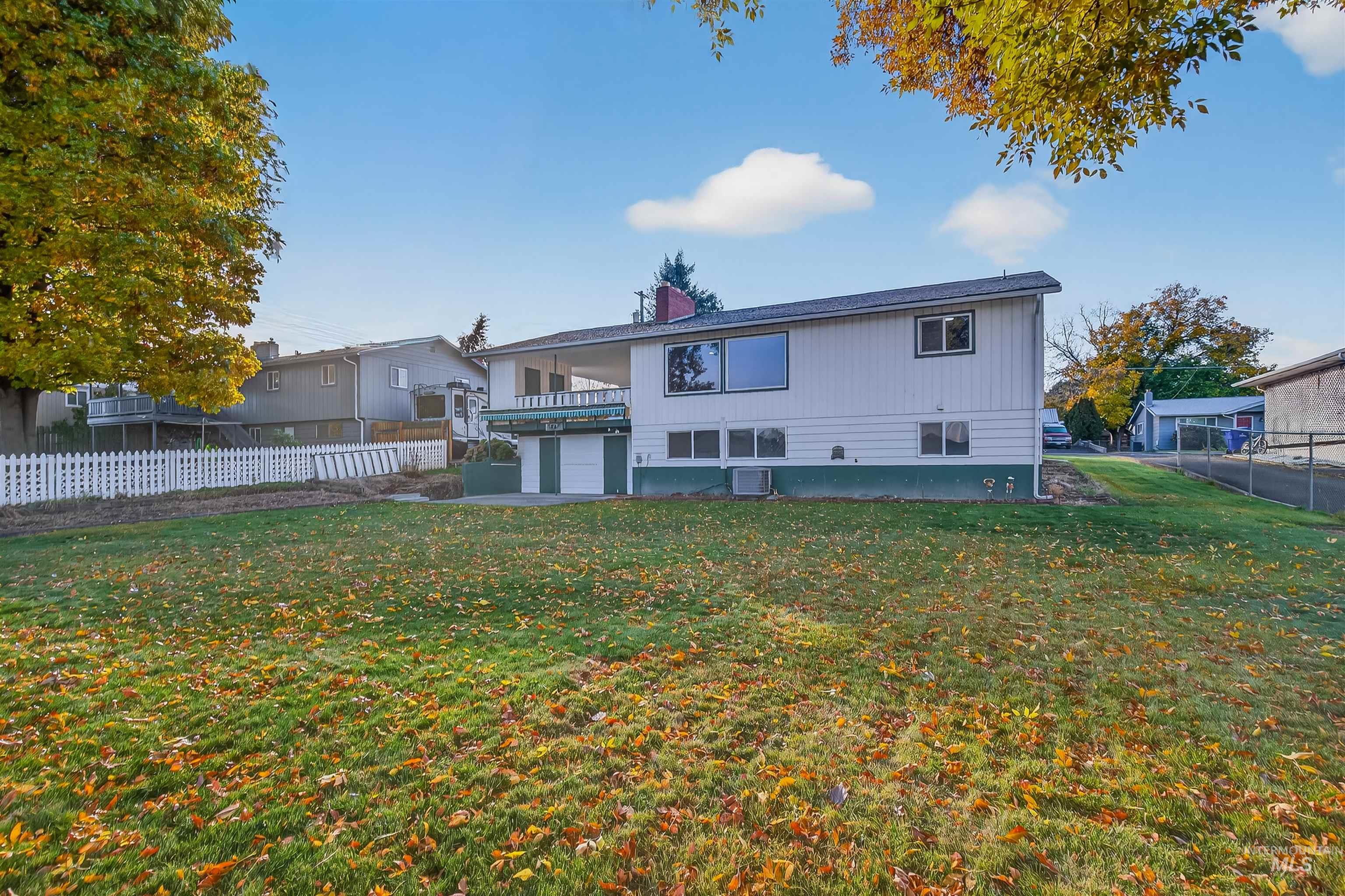 Rear view of property with a balcony, a chimney, and a patio area