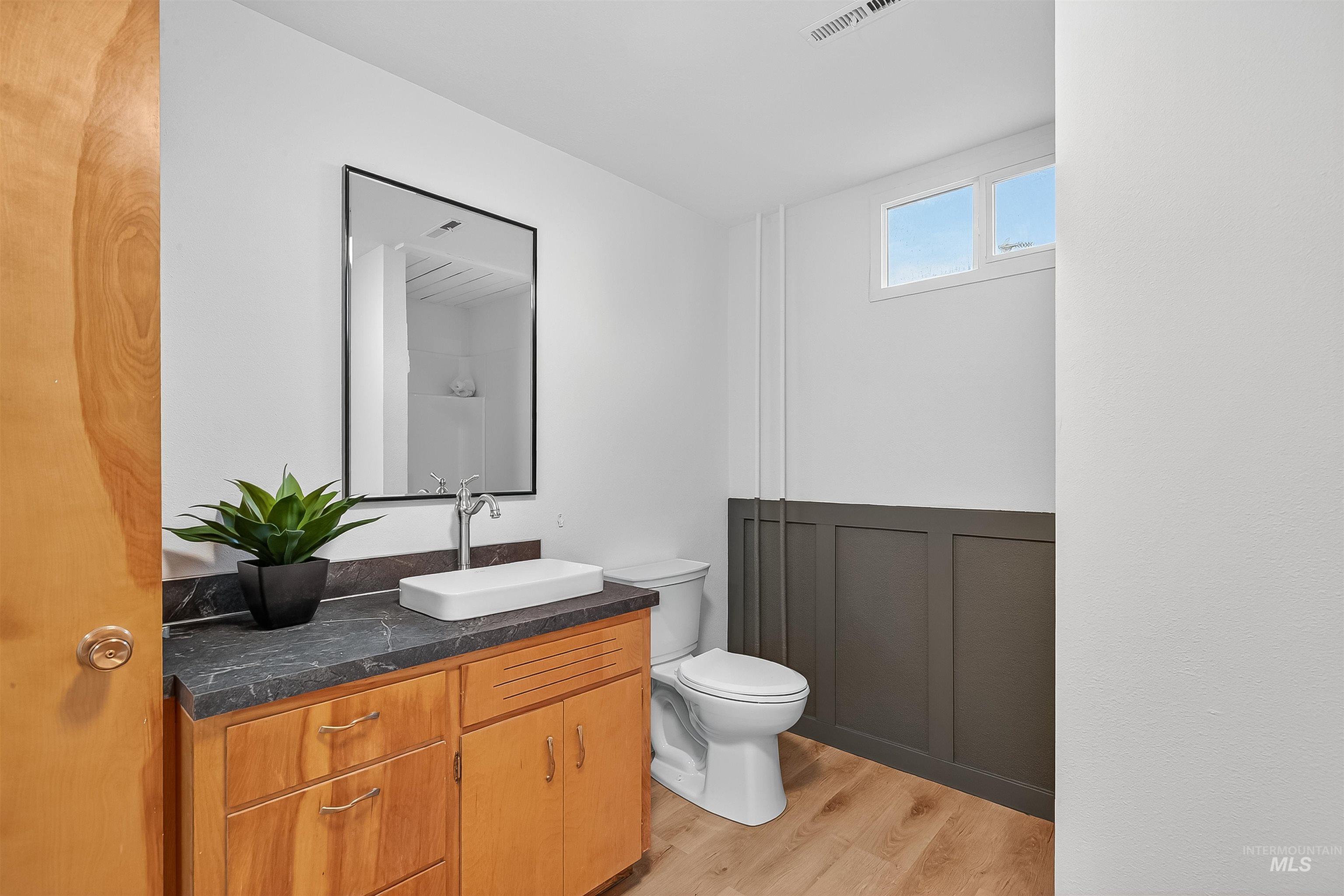 Full bath with light wood-style floors, vanity, and a shower