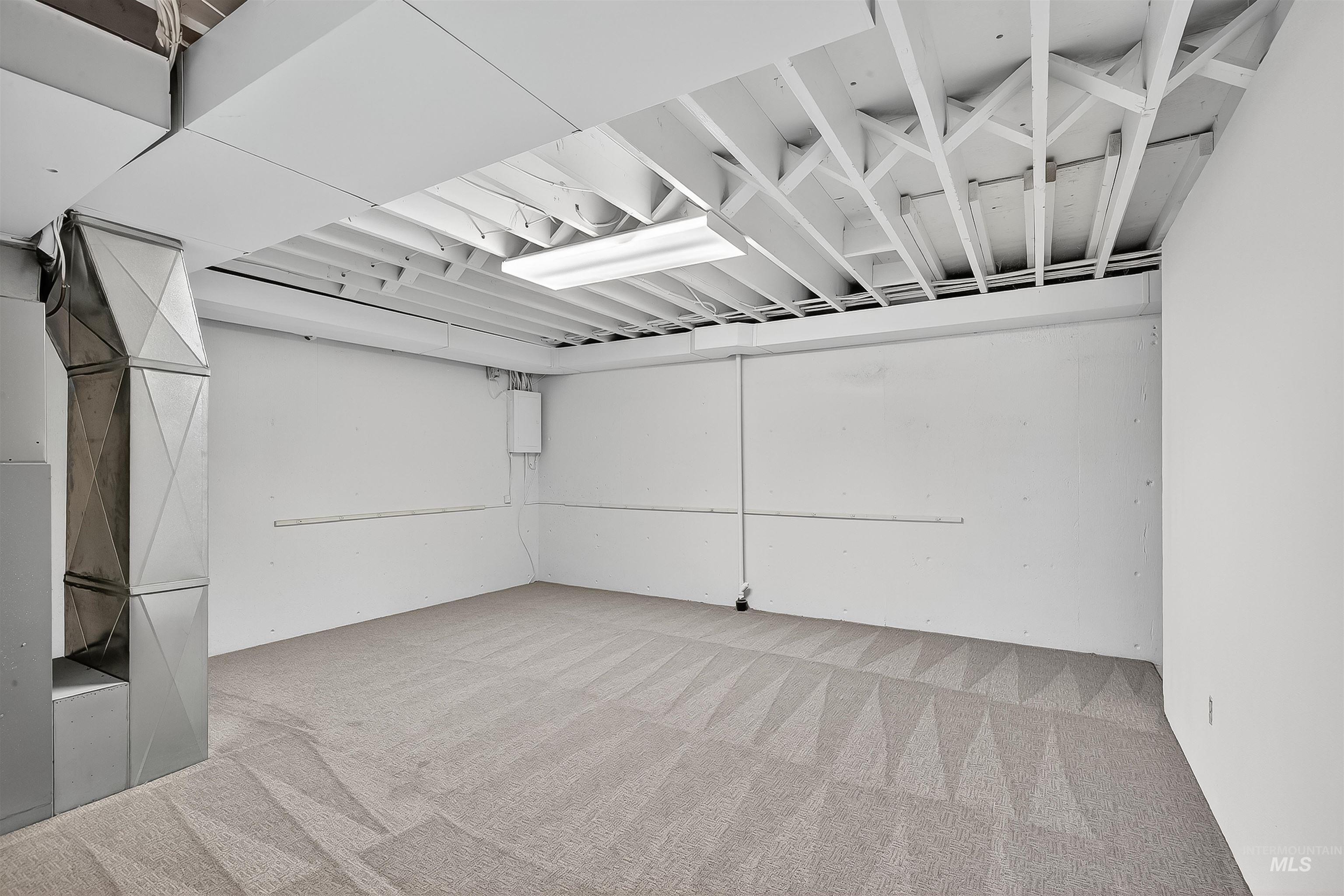 Below grade area featuring light colored carpet and heating unit