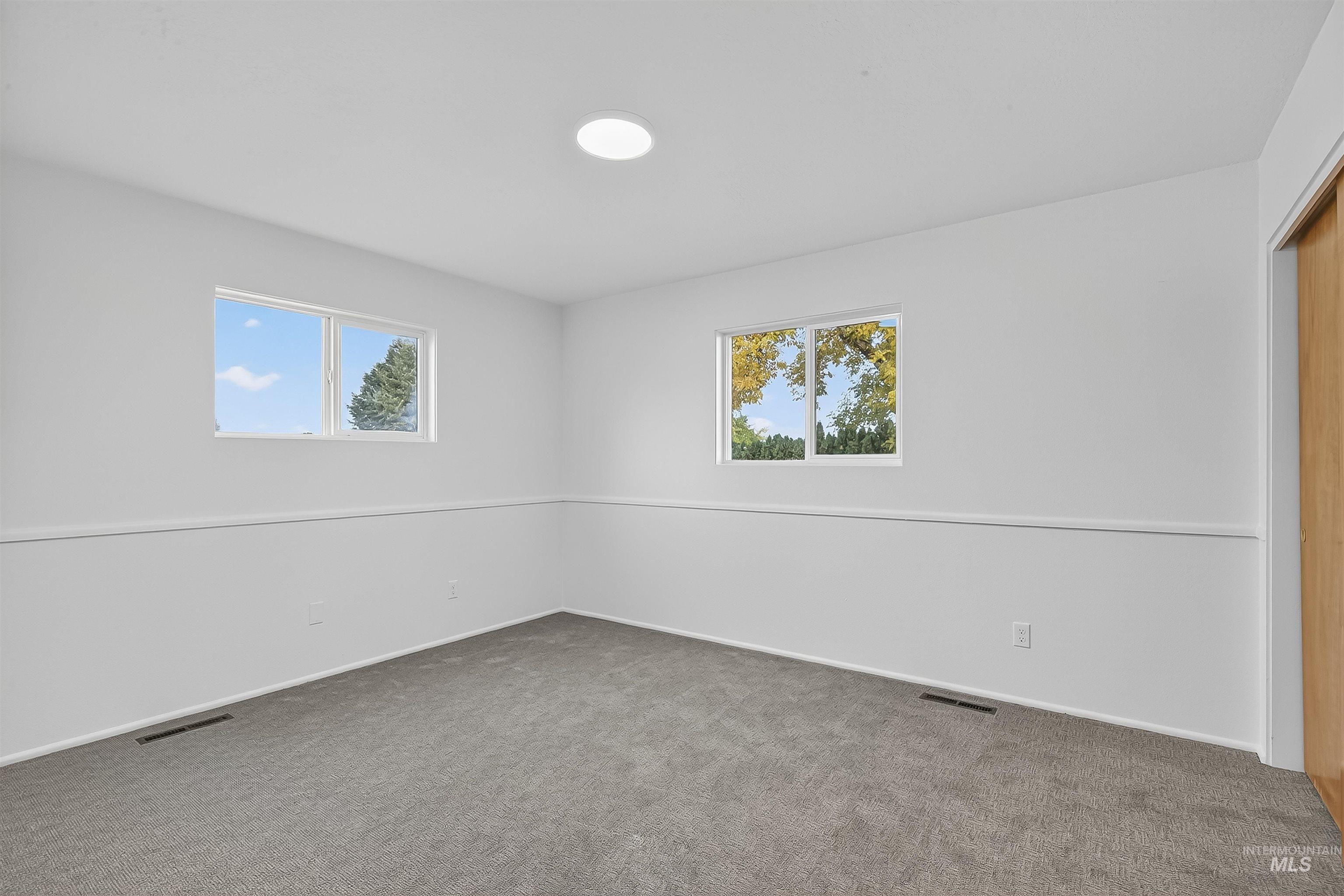 Carpeted empty room featuring plenty of natural light