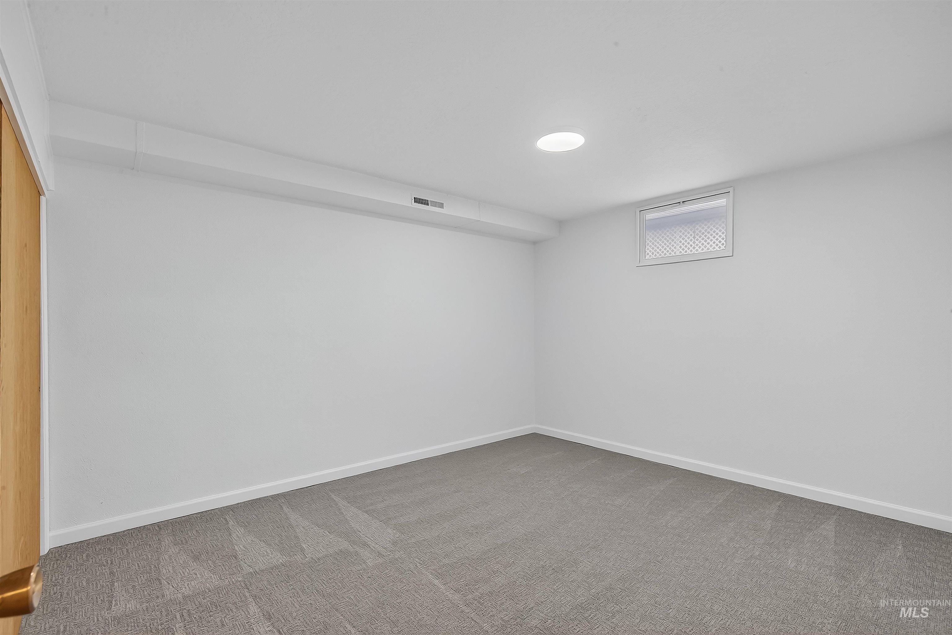 Below grade area featuring light carpet and baseboards